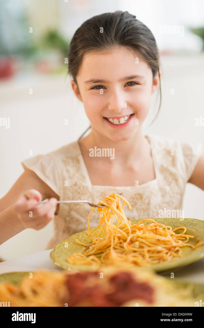 Portrait of girl (8-9) eating pasta Stock Photo
