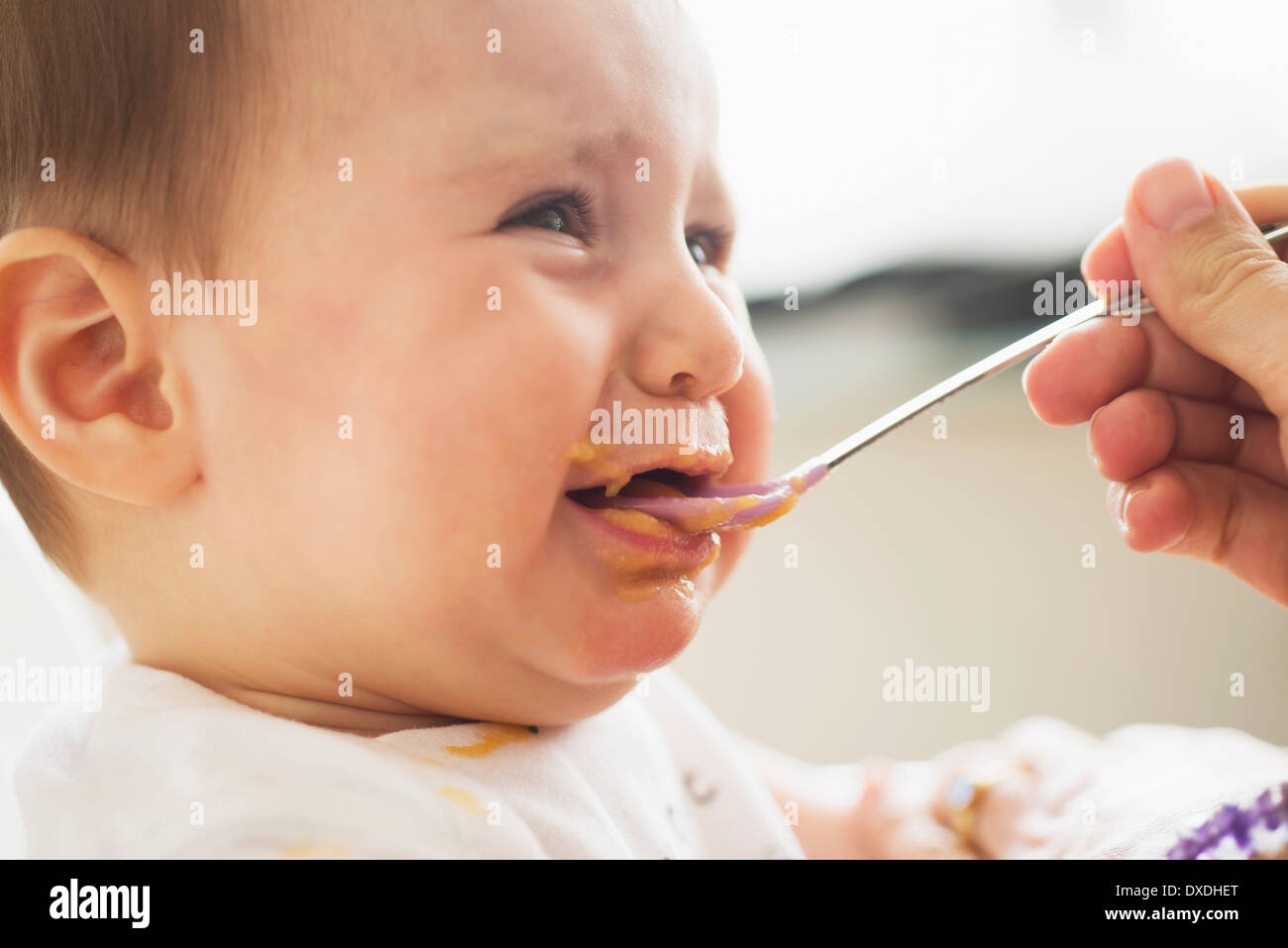 Close-up of baby girl (12-17 months) being spoon fed Stock Photo
