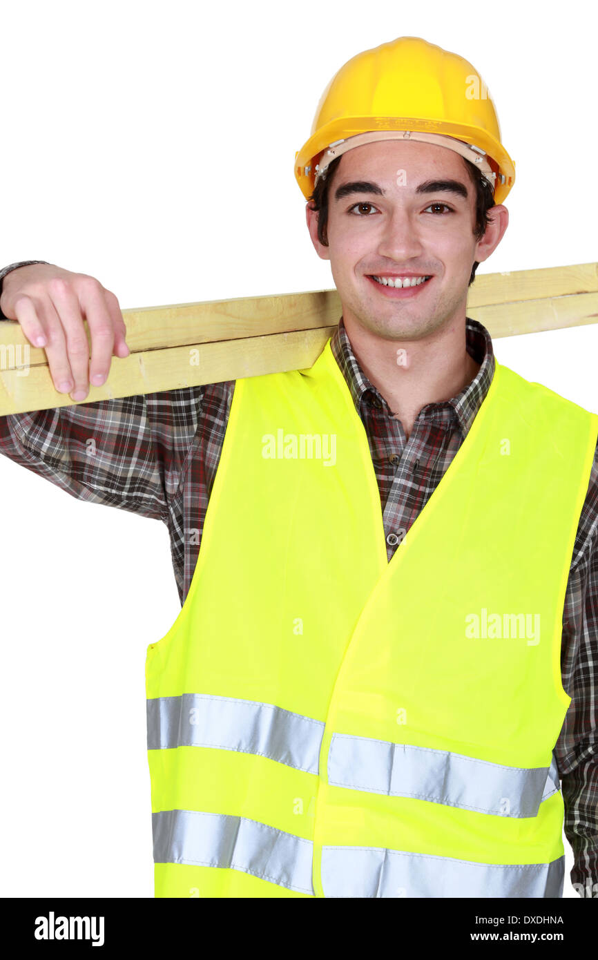 Young joiner carrying planks Stock Photo