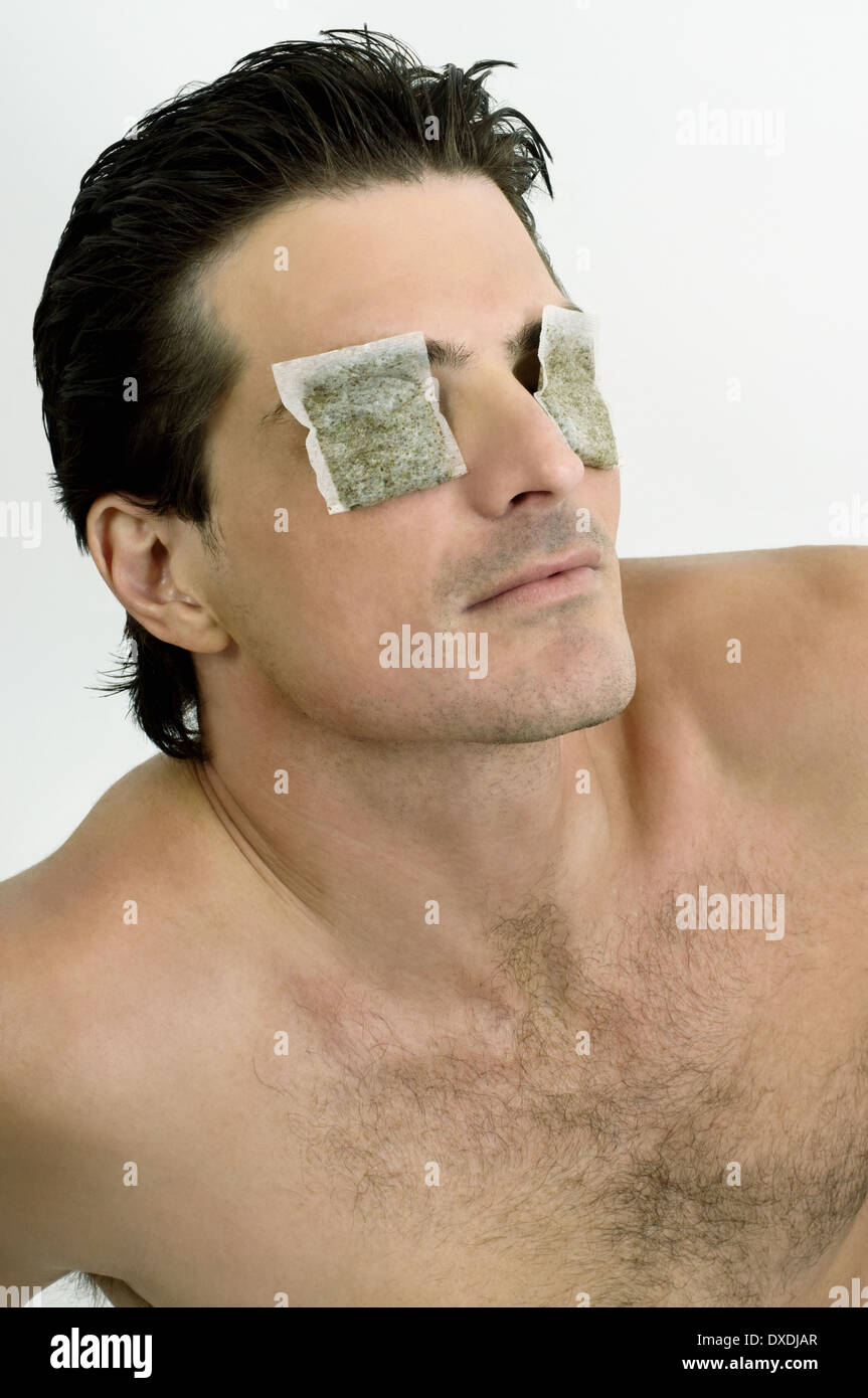 Young man with tea bags on his eyes Stock Photo - Alamy