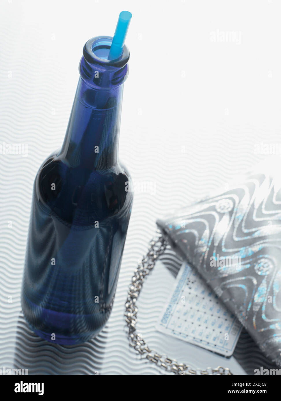 Bottle of Alcopop with Evening Bag, Studio Shot Stock Photo