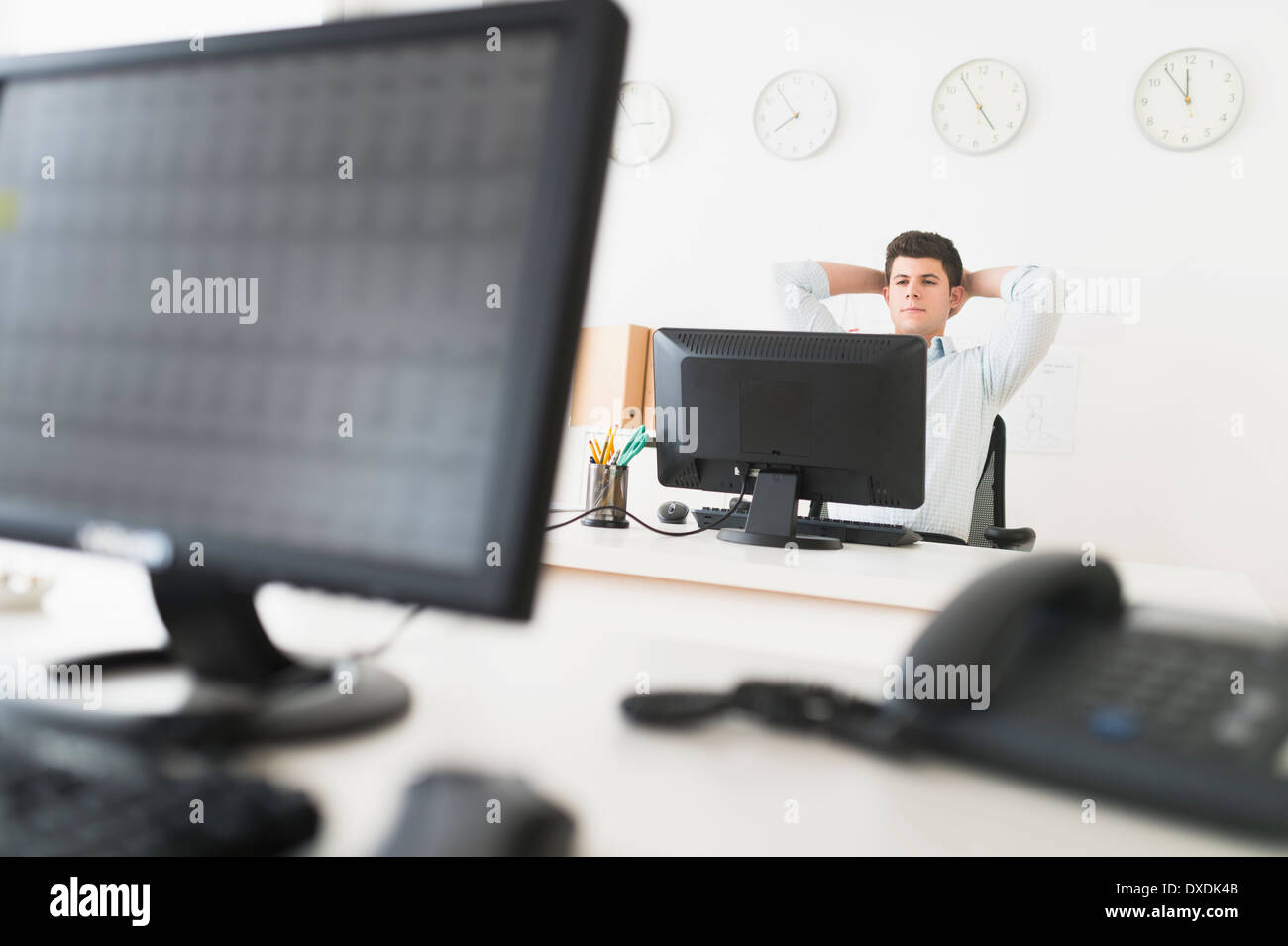 Young man sitting in front of desk and working Stock Photo