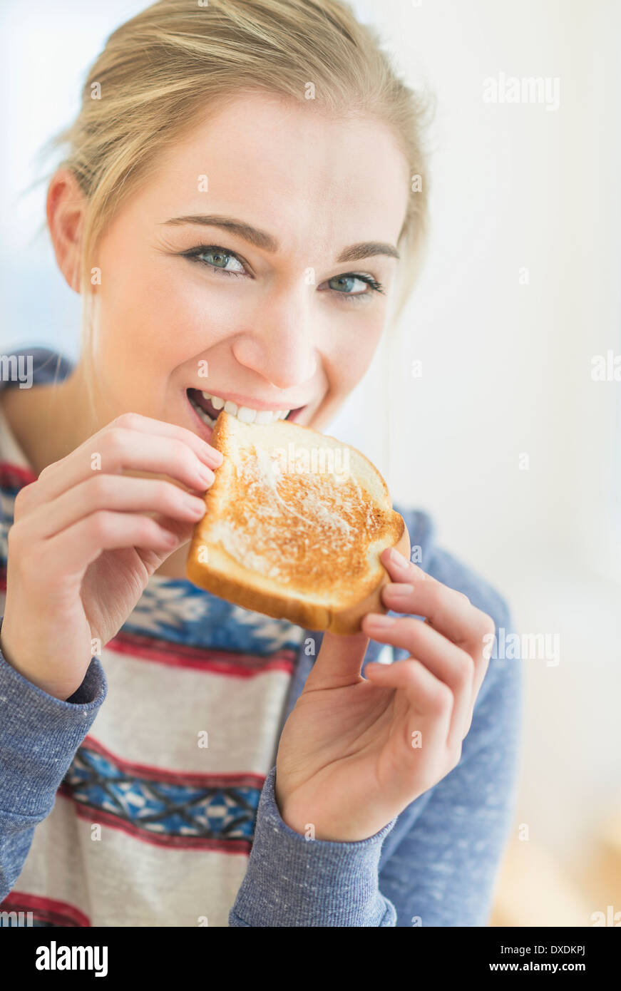 Woman eating toast Stock Photo - Alamy