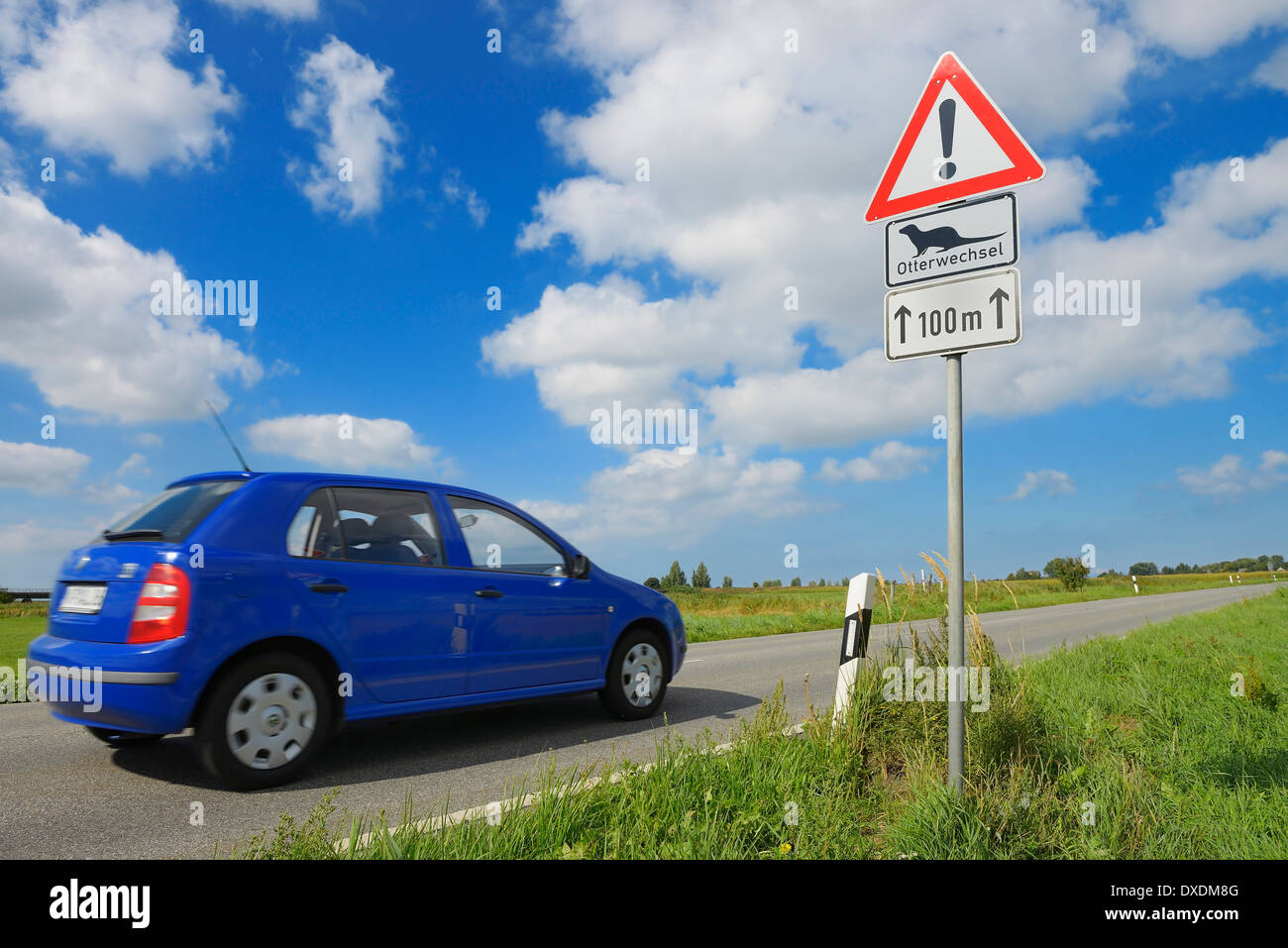Car on Road and Otter Crossing Sign, Fischland-Darss-Zingst, Mecklenburg-Western Pomerania, Germany Stock Photo