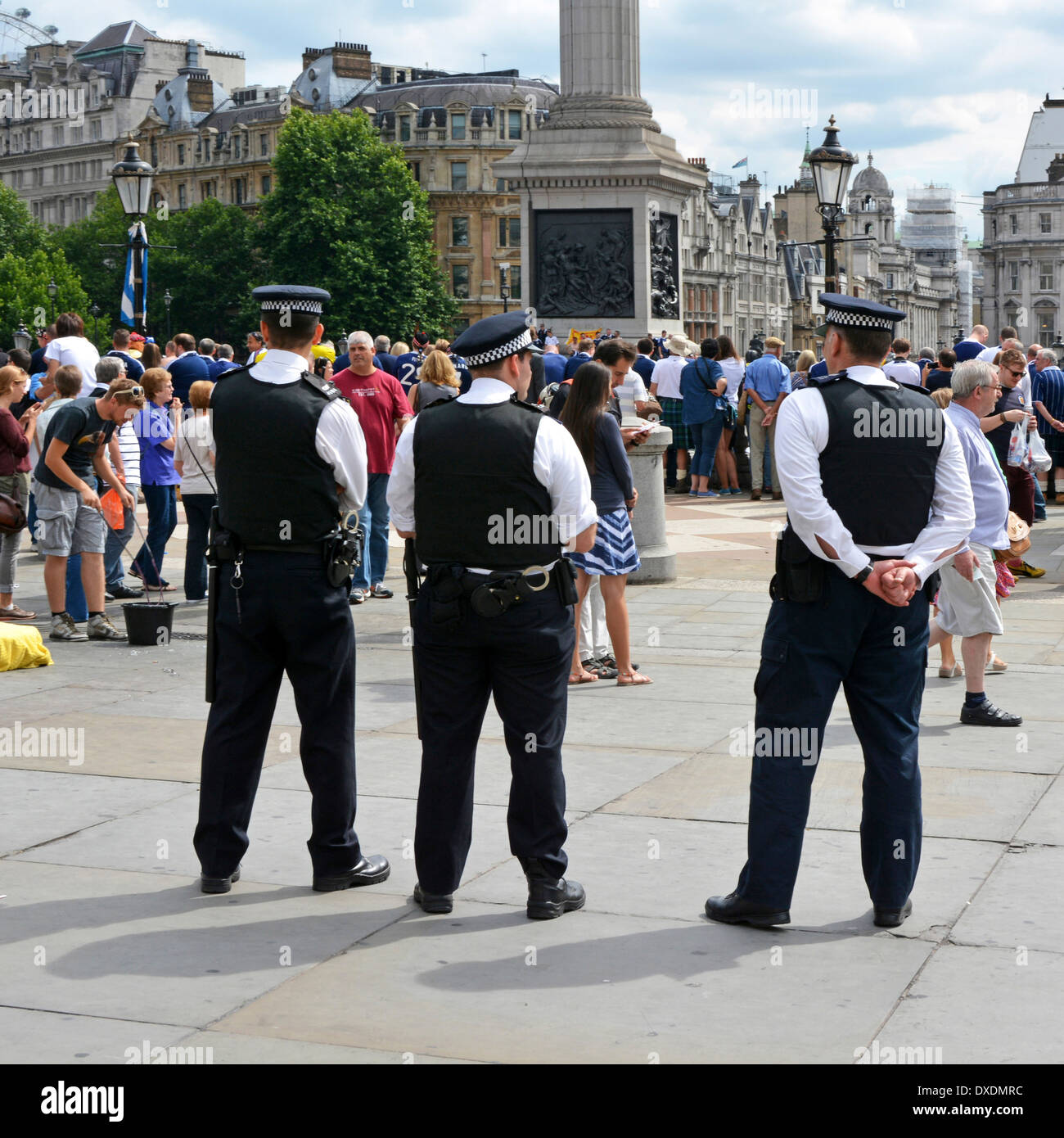 Three metropolitan police officers watching crowds of Scotland football fans prior to an international match at Wembley Stock Photo