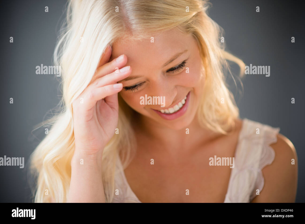 Portrait of young woman braiding hair Stock Photo