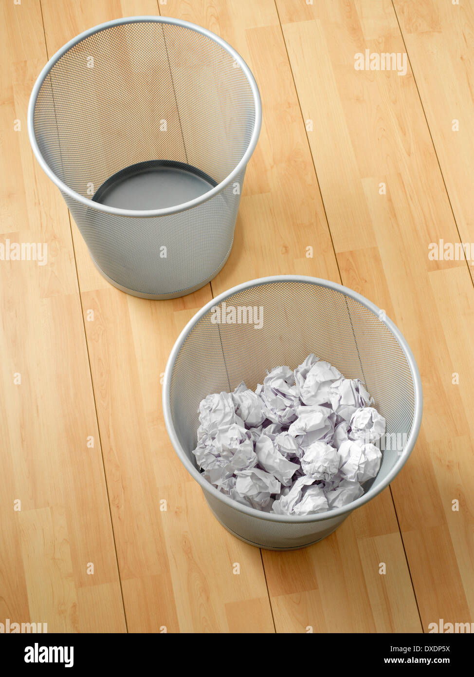 Overhead view of empty and used waste baskets on wooden floor, studio