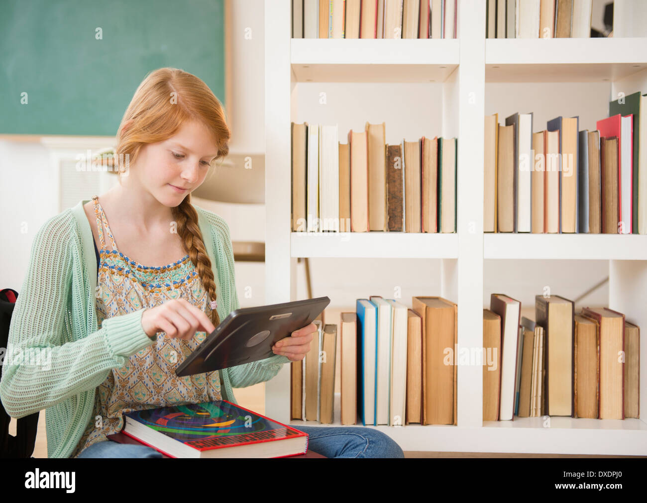 Girl (12-13) using tablet PC in classroom Stock Photo
