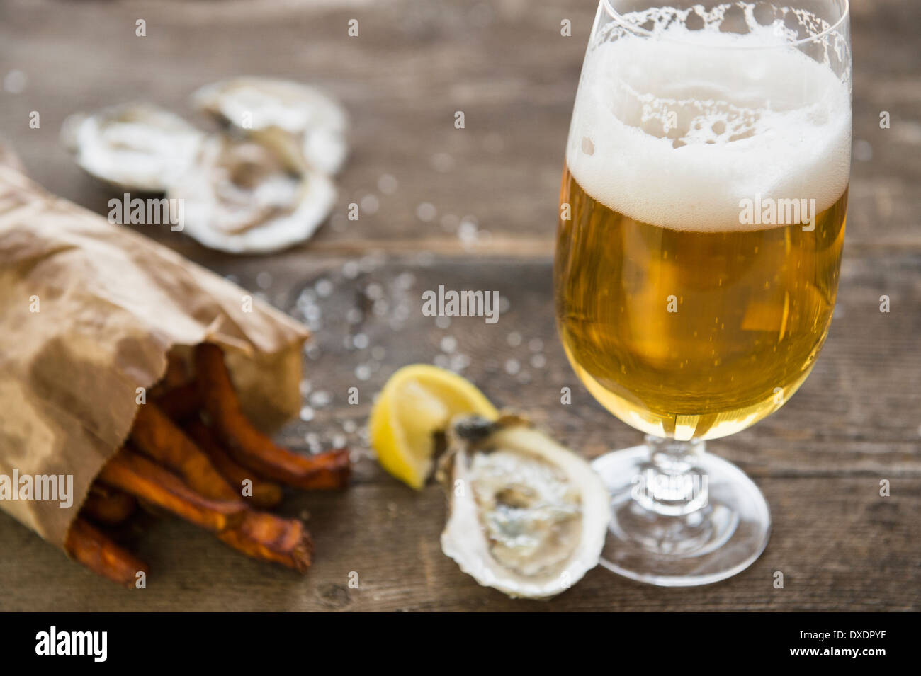 Studio shot of glass of beer, oysters and french fries Stock Photo Alamy