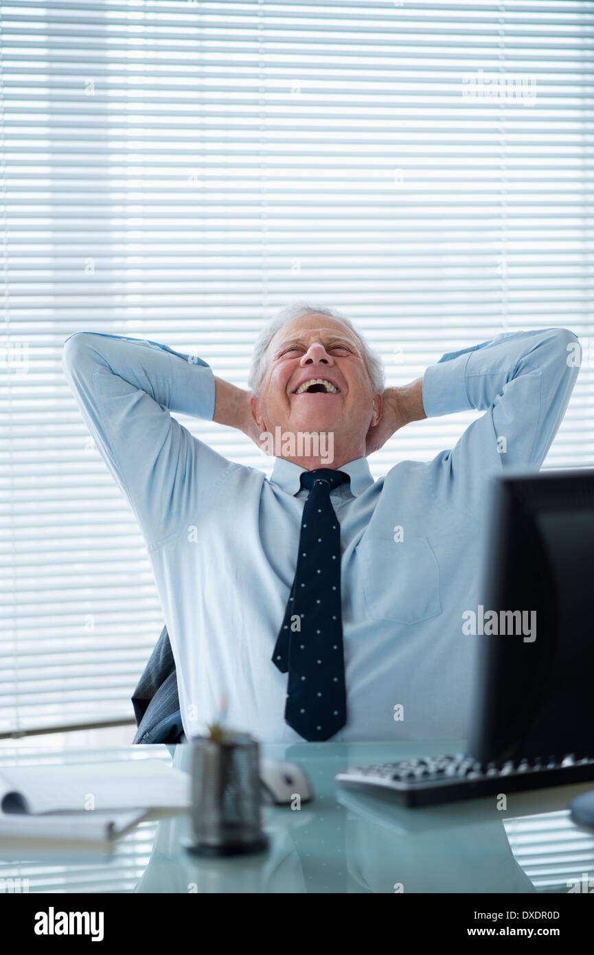 Senior man relaxing in office Stock Photo