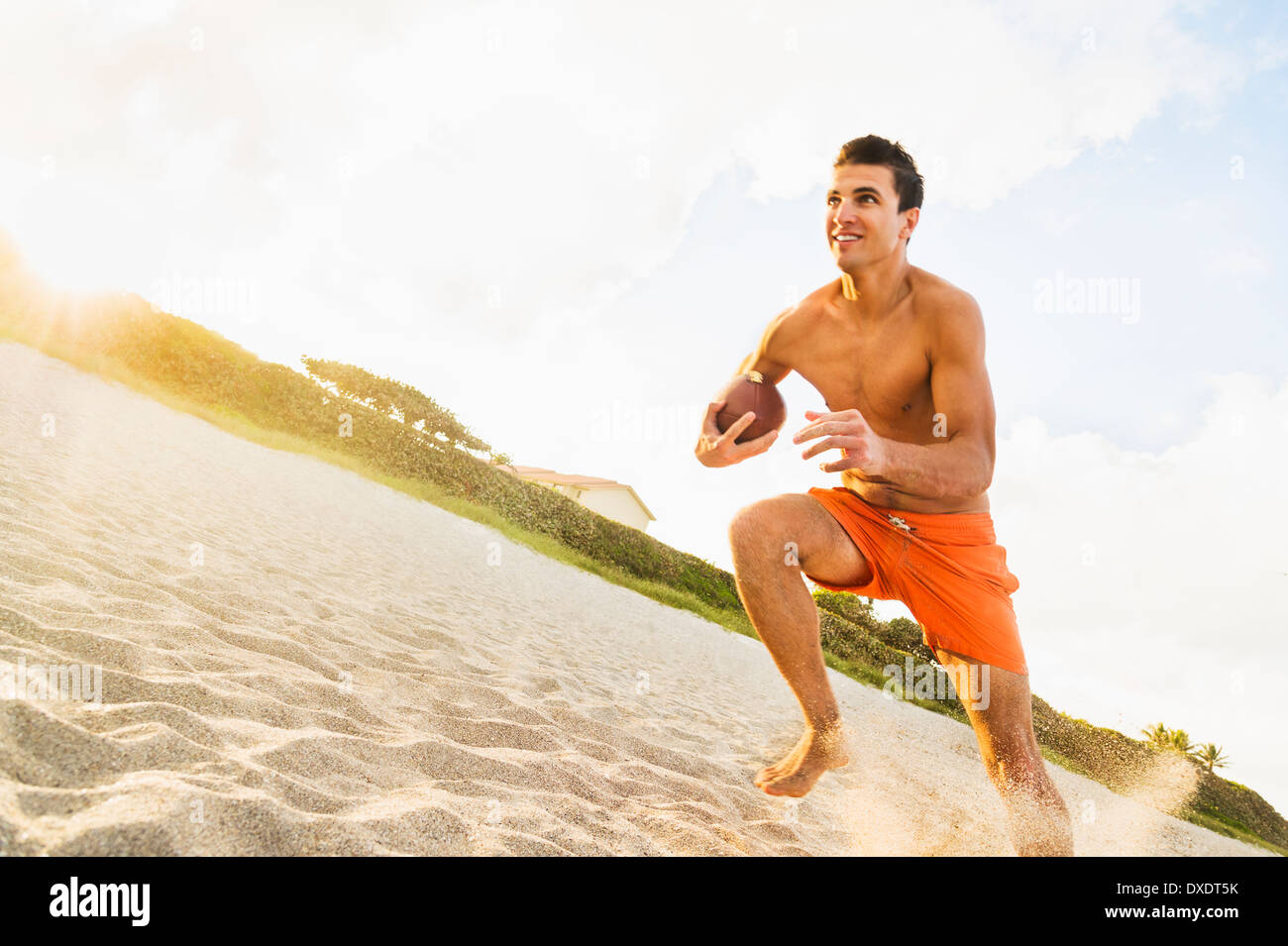 Young man playing football on beach, Jupiter, Florida, USA Stock Photo