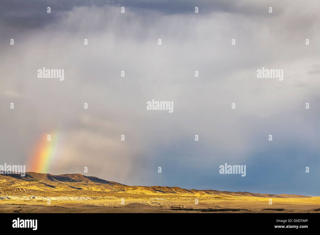 heavy storm clouds and rainbow over prairie in northern Colorado - Soapstone Prairie Natural Area Stock Photo
