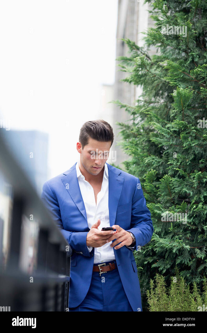 Young businessman relaxing when text messaging, New York City, New York State, USA Stock Photo