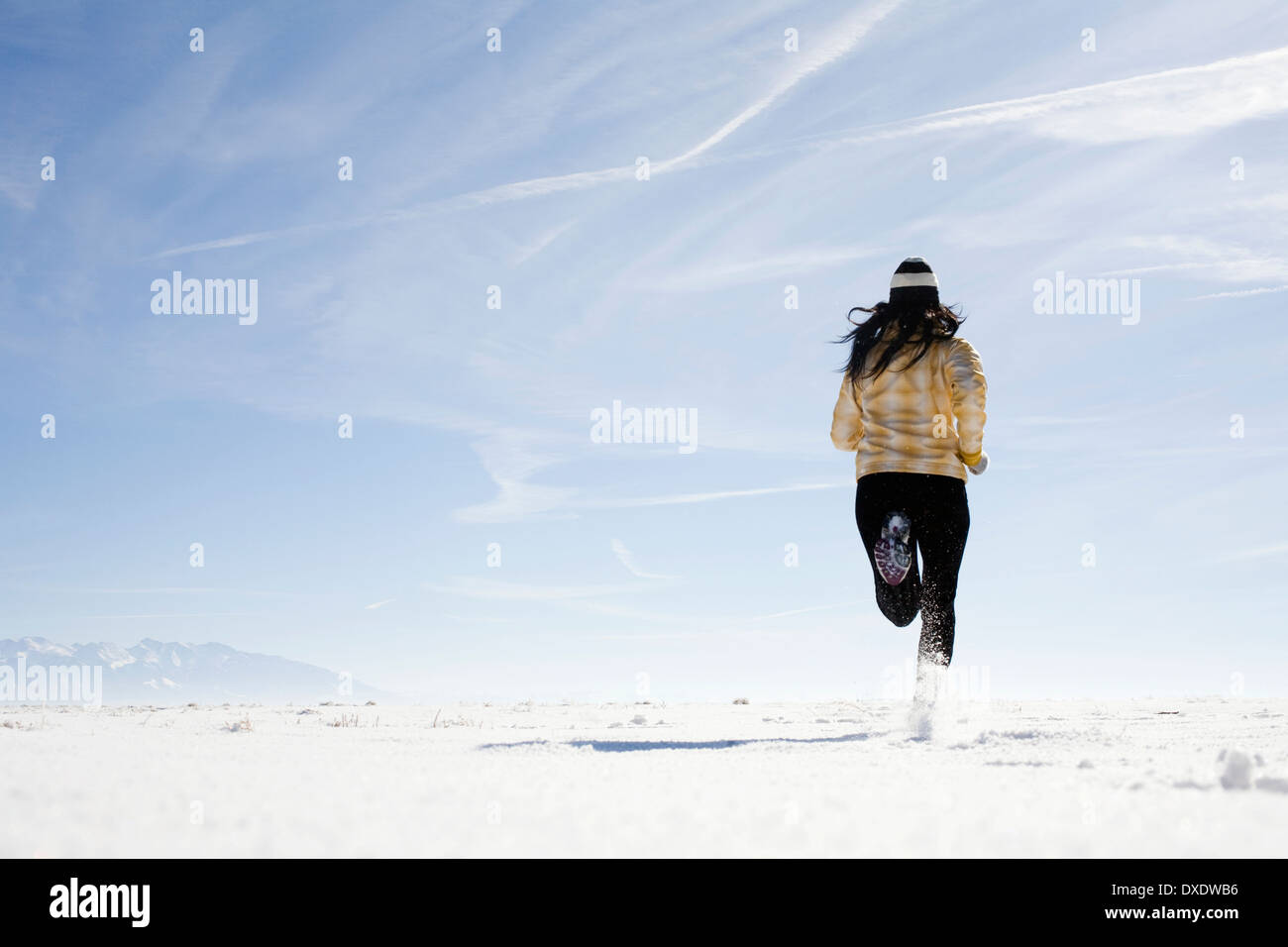 Woman running on snow, Colorado, USA Stock Photo