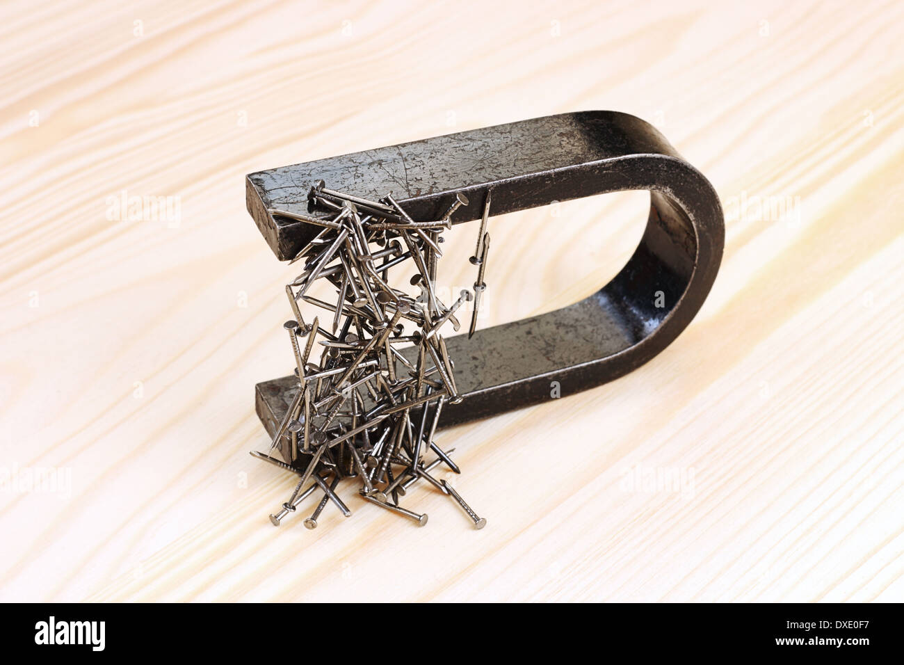 Magnet with steel nails on wooden background Stock Photo