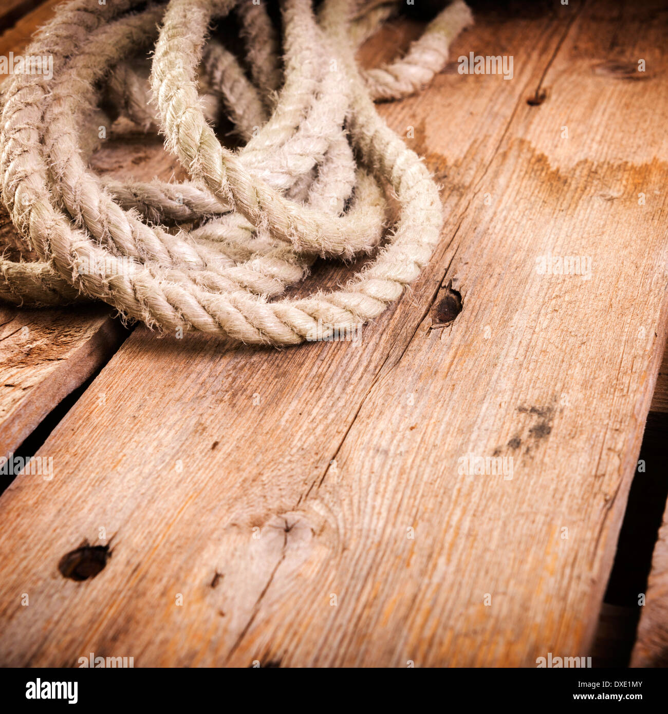 Old rope twisted and tied in a bundle on a rough wooden background