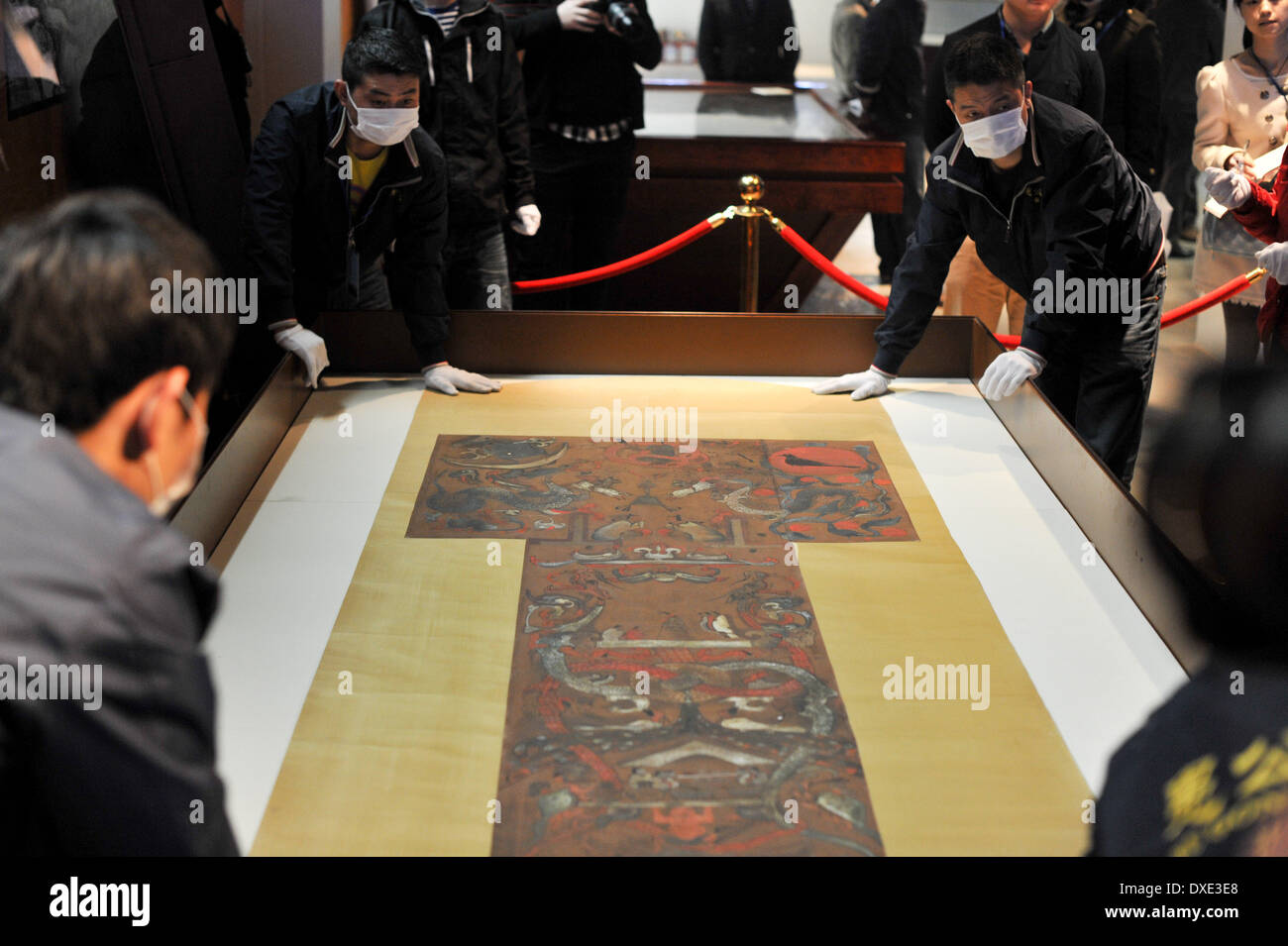 (140325) -- CHANGSHA, March 25, 2014 (Xinhua) -- Staff members arrange the T-shaped painting on silk, the highlight of the Hunan Provincial Museum, at the museum in Changsha, capital of central China's Hunan Province, March 25, 2014. More than 50 pieces (sets) of cultural relics from the Mawangdui Tombs of the Han Dynasty (206 B.C. - 220 A.D.), located in the eastern suburbs of Changsha, will be re-presented at the museum from March 29. The museum started its renovation in June 2012. (Xinhua/Bai Yu) (wyo) Stock Photo