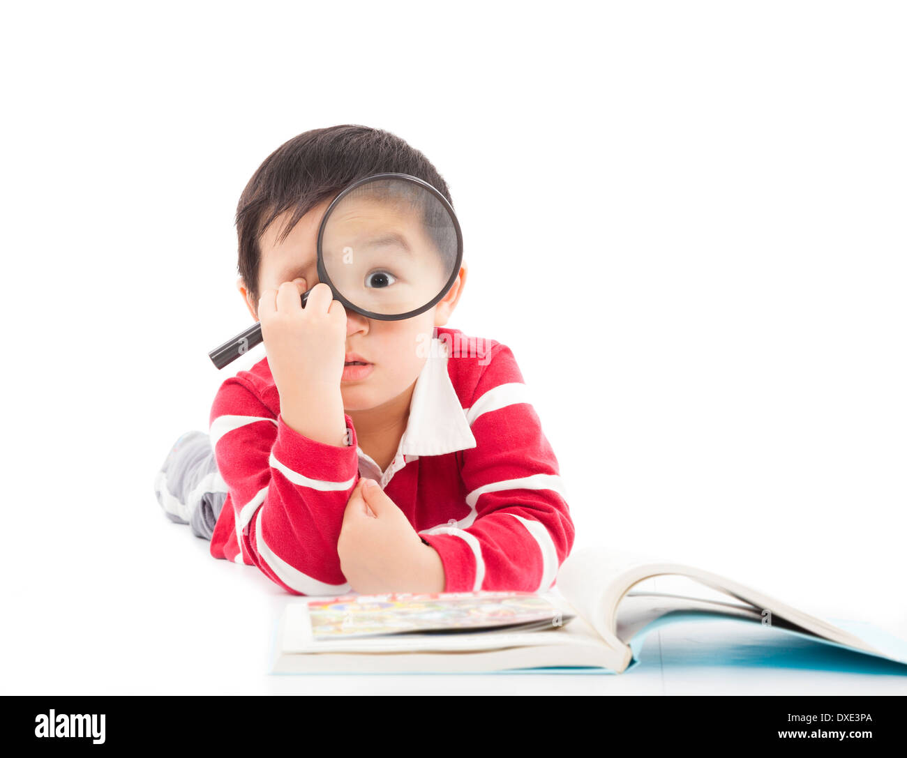 surprised kid is holding magnifying glass Stock Photo