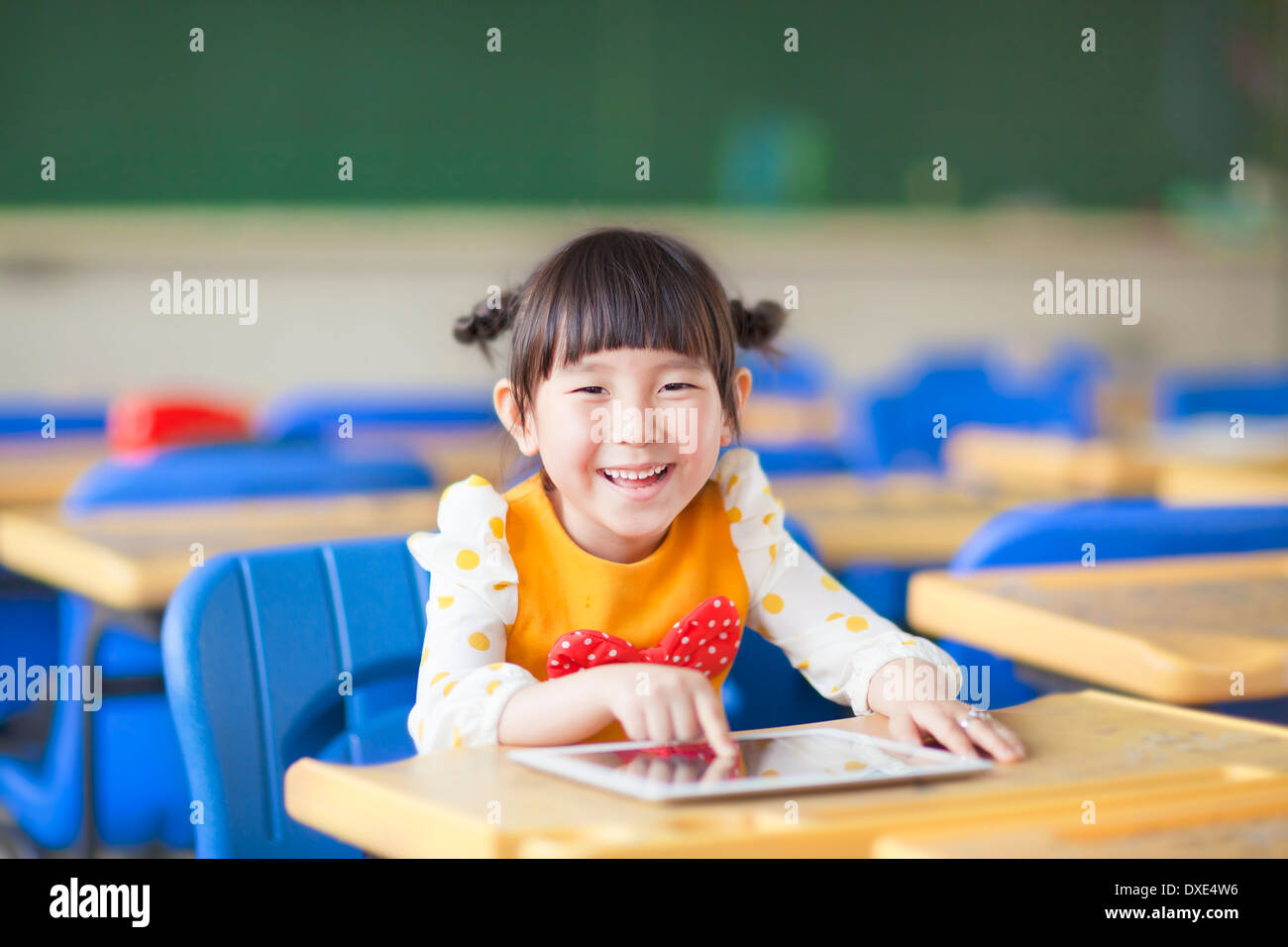 smiling kid using tablet  or ipad in a classroom Stock Photo