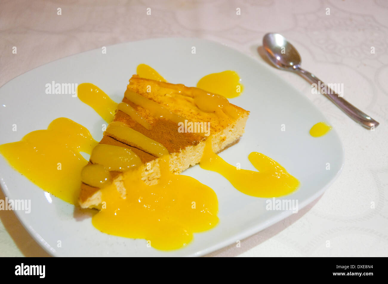 Dessert: cheese cake with mango cream and cinnamon. Close view. Stock Photo