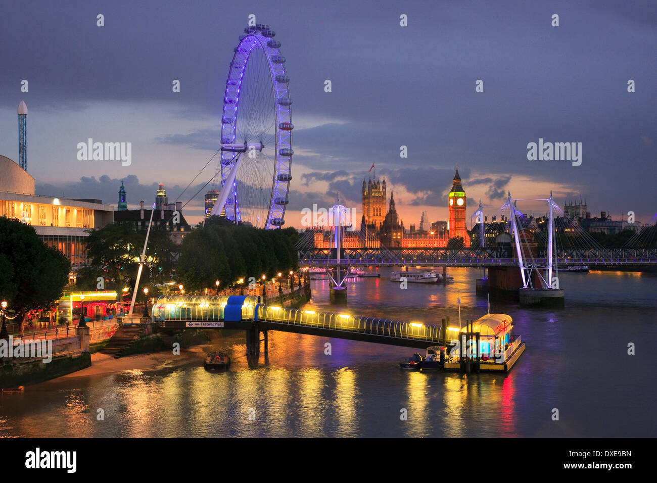 London at dusk with the London eyey, Jubilee bridge and Houses of parliament in view. As seen from waterloo bridge. England. Stock Photo