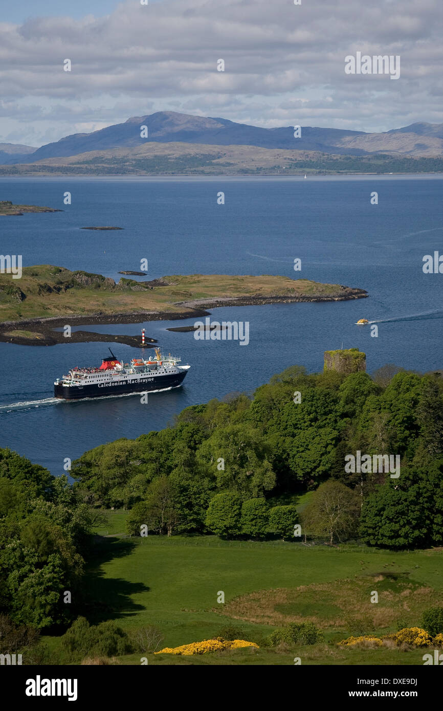 The Calmac vessel M.V. Isle of Mull ferry passes the Clan MacDougall stronghold of Dunollie Castle, with a distant mull in view, Stock Photo