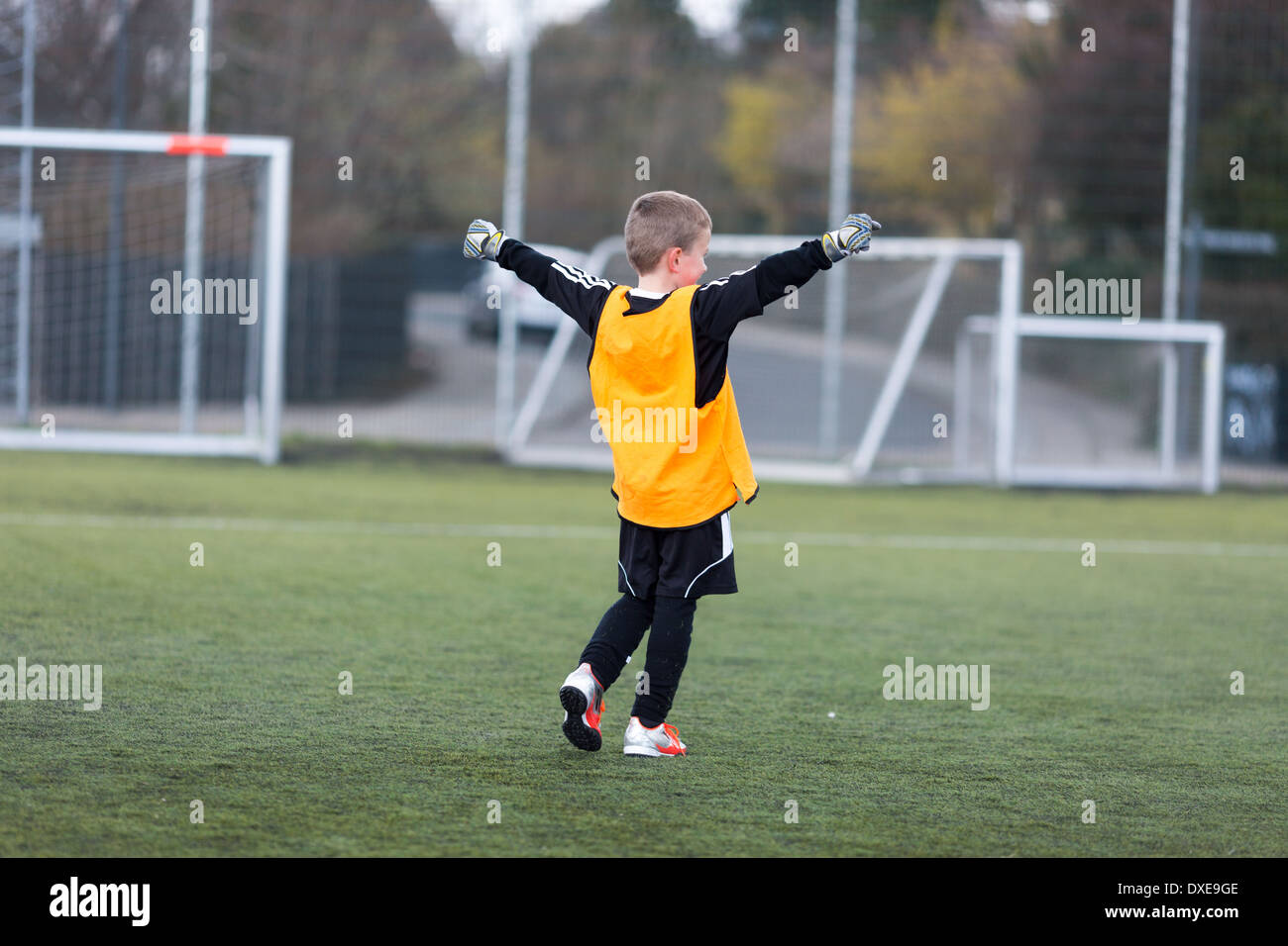 Young goal keeper celebrating a goal scored by his team. Stock Photo
