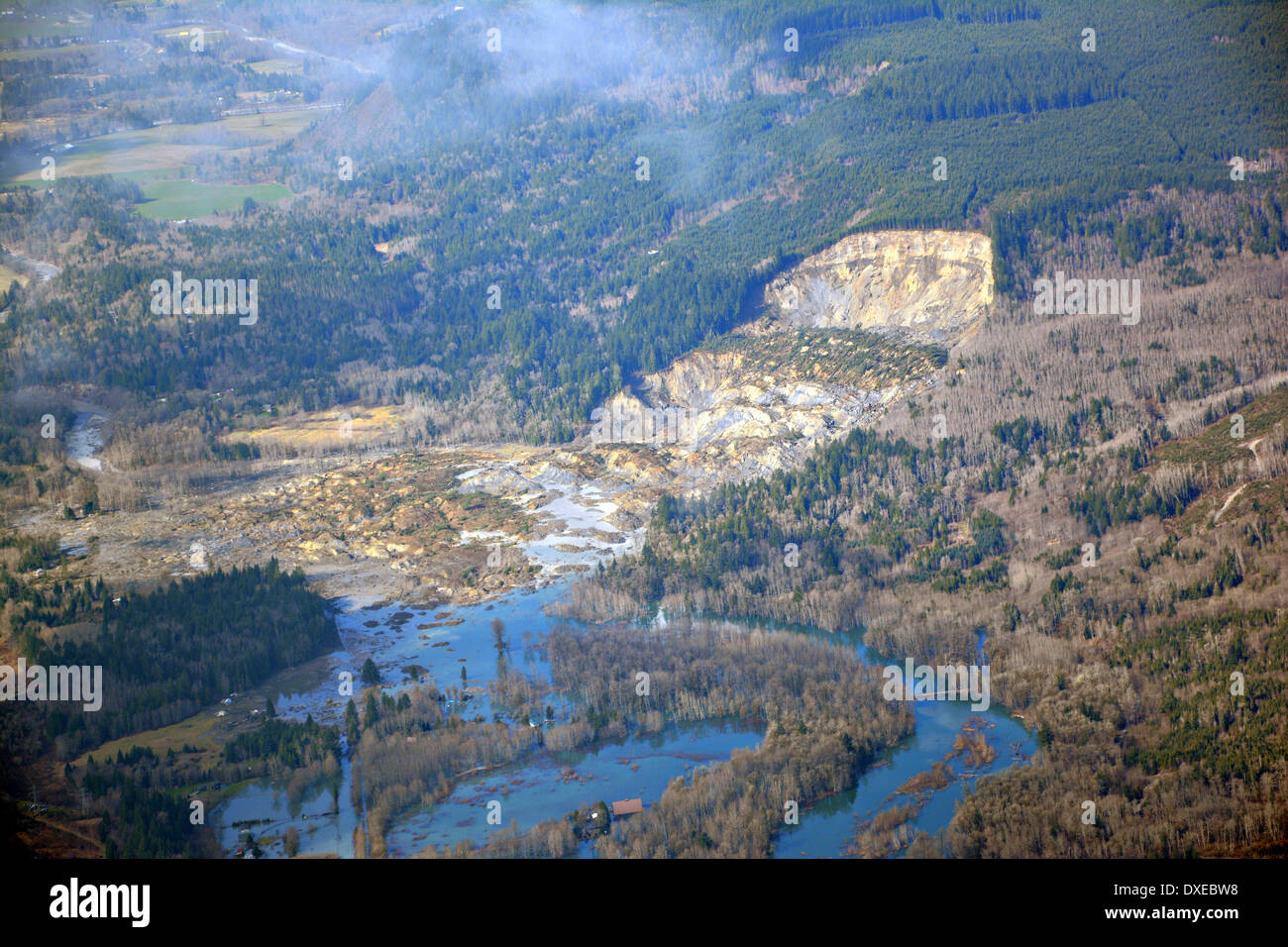 Aerial view of the landslide that blocked the Stillaguamish River burying State Route 530 and causing a massive mudslide killing at least fourteen people and destroying a small riverside village in northwestern Washington state March 23, 2014 in Oso, Washington. Officials report that 176 people are still missing and feared dead. Stock Photo