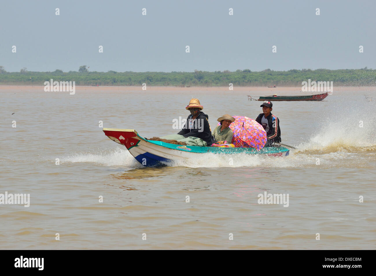 'Long tail' speed boat ferrying  people  and produce to their floating villages on Tonle Sap Lake in the dry season, Cambodia, Southeast Asia Stock Photo