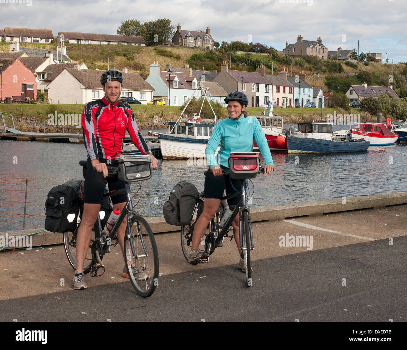 Chris and Sarah on their bycycles on the quayside in helmsdale,caithness. Stock Photo