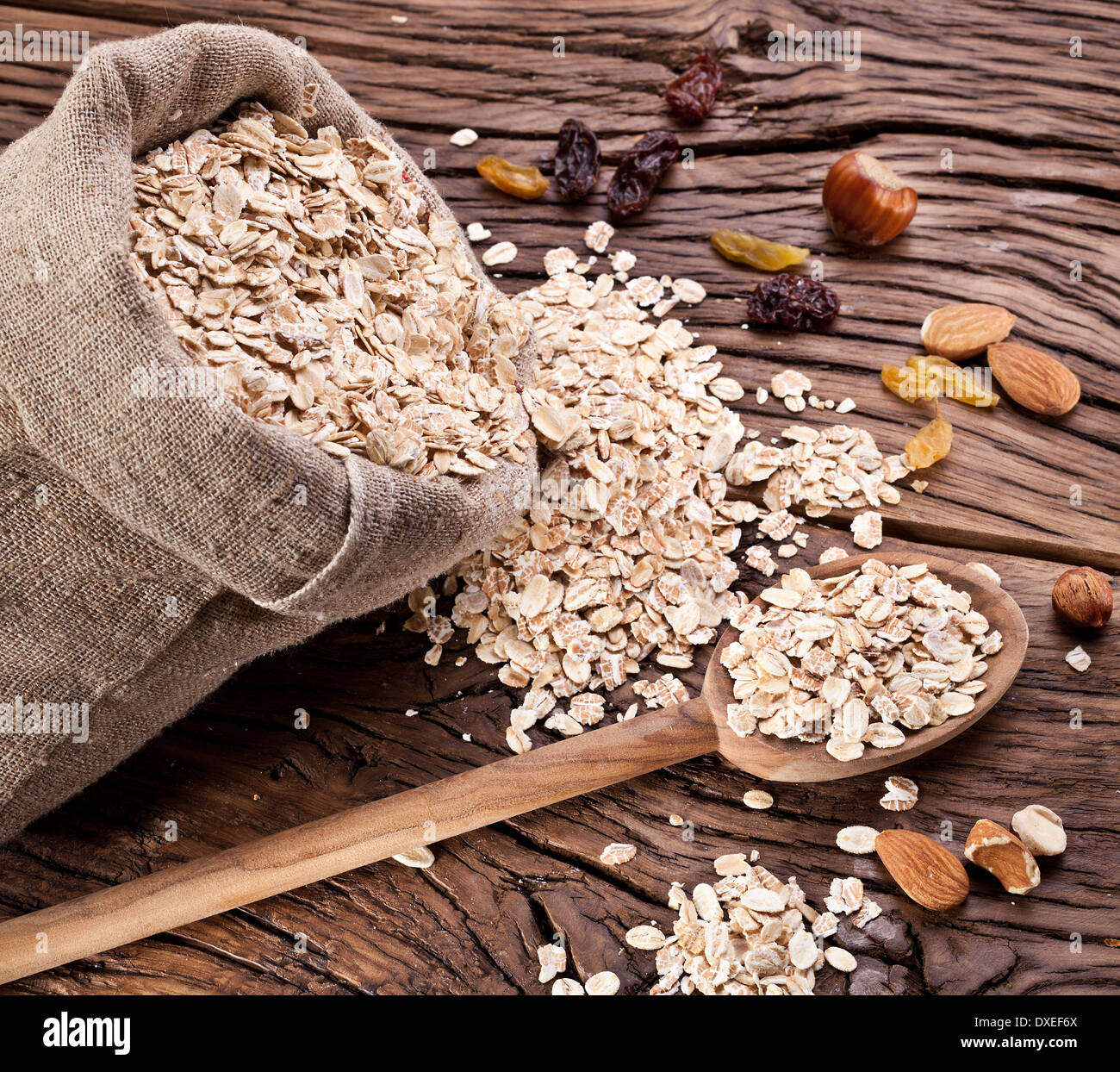 Rolled oats in the sack on old wooden table. Stock Photo
