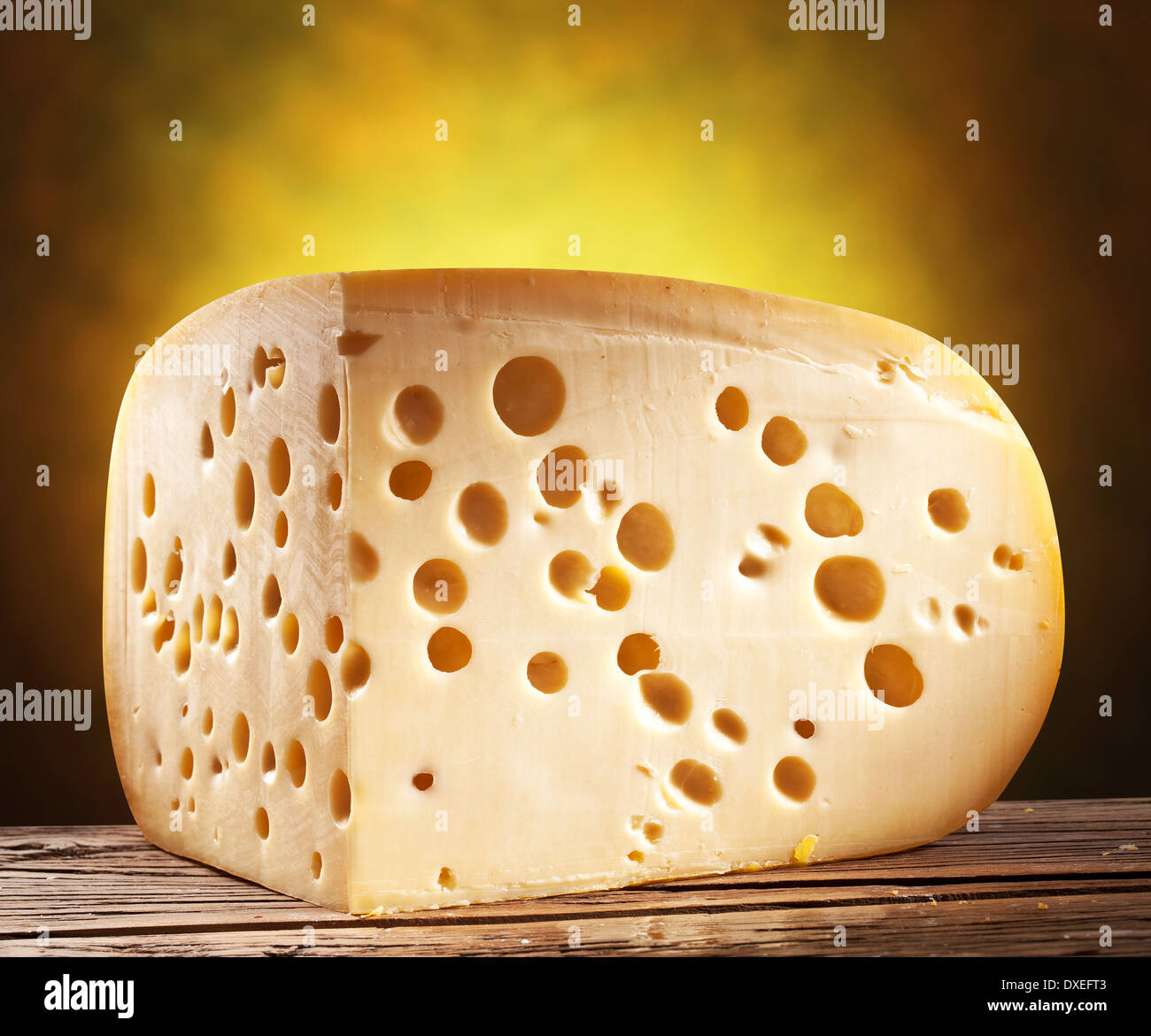 Quarter of Emmental cheese head on wooden table. Stock Photo