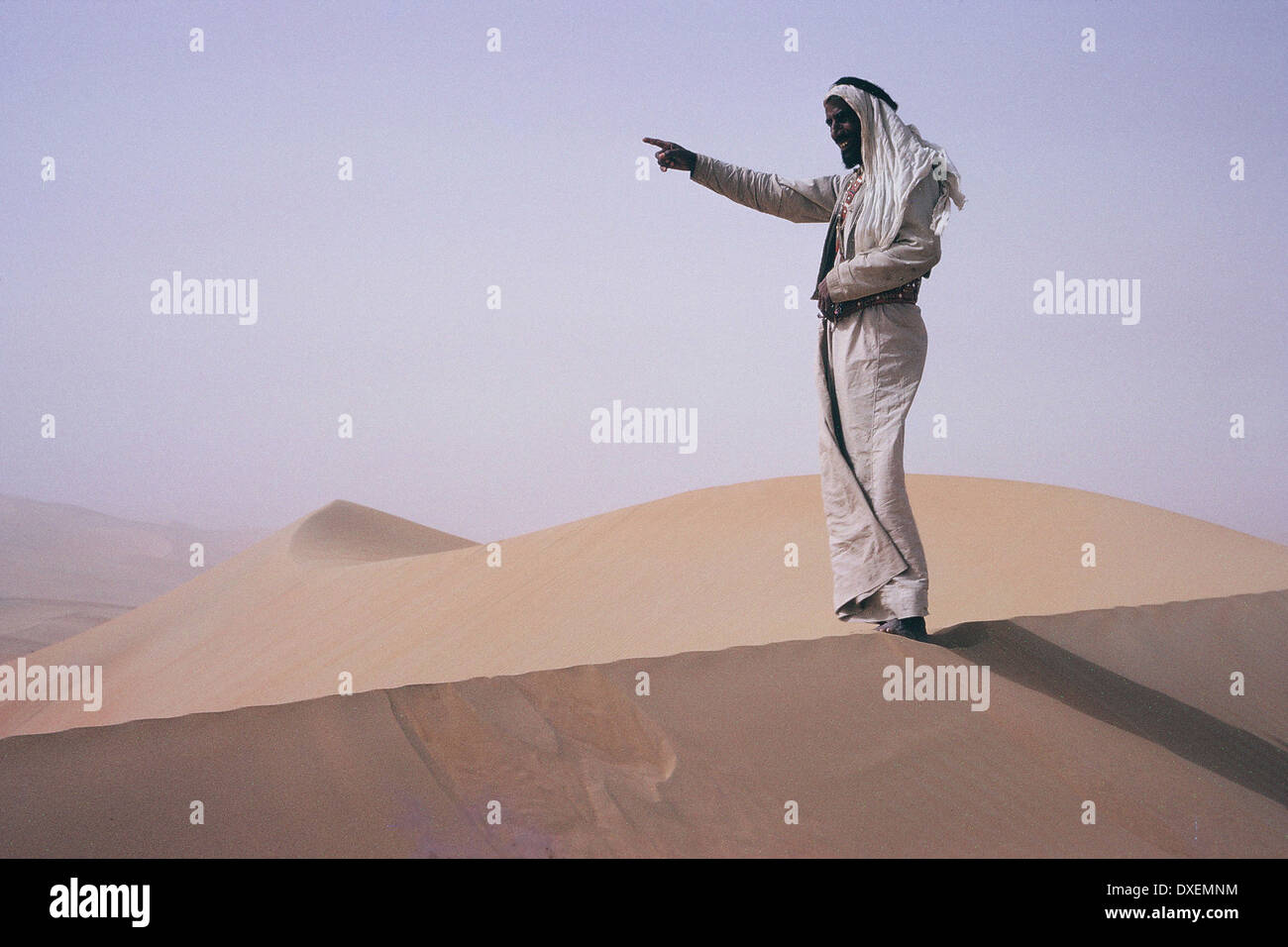 Sheikh Shakhbut, Ruler of Abu Dhabi  pointing the way across the desert, 1964 Stock Photo