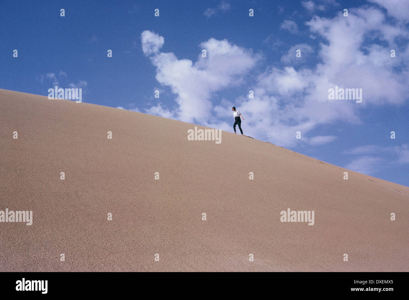 Girl climbing sand dune in the desert Stock Photo Alamy