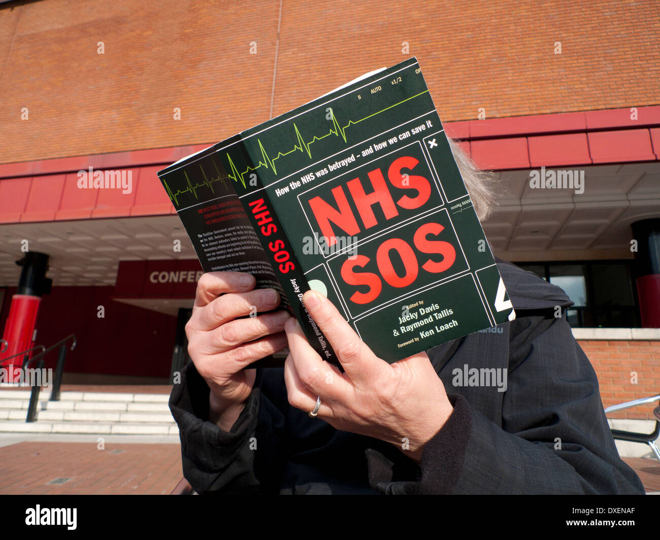 Woman reading NHS SOS book in the courtyard ot The British Library, Euston London England UK   KATHY DEWITT Stock Photo