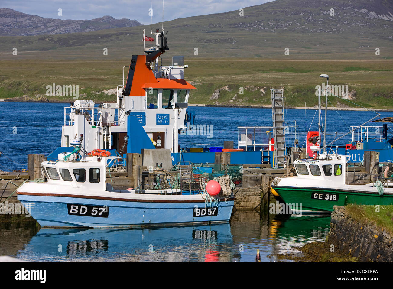 boats and the Jura ferry at Port Askaig pier Islay with the paps of jura in distance.Island of