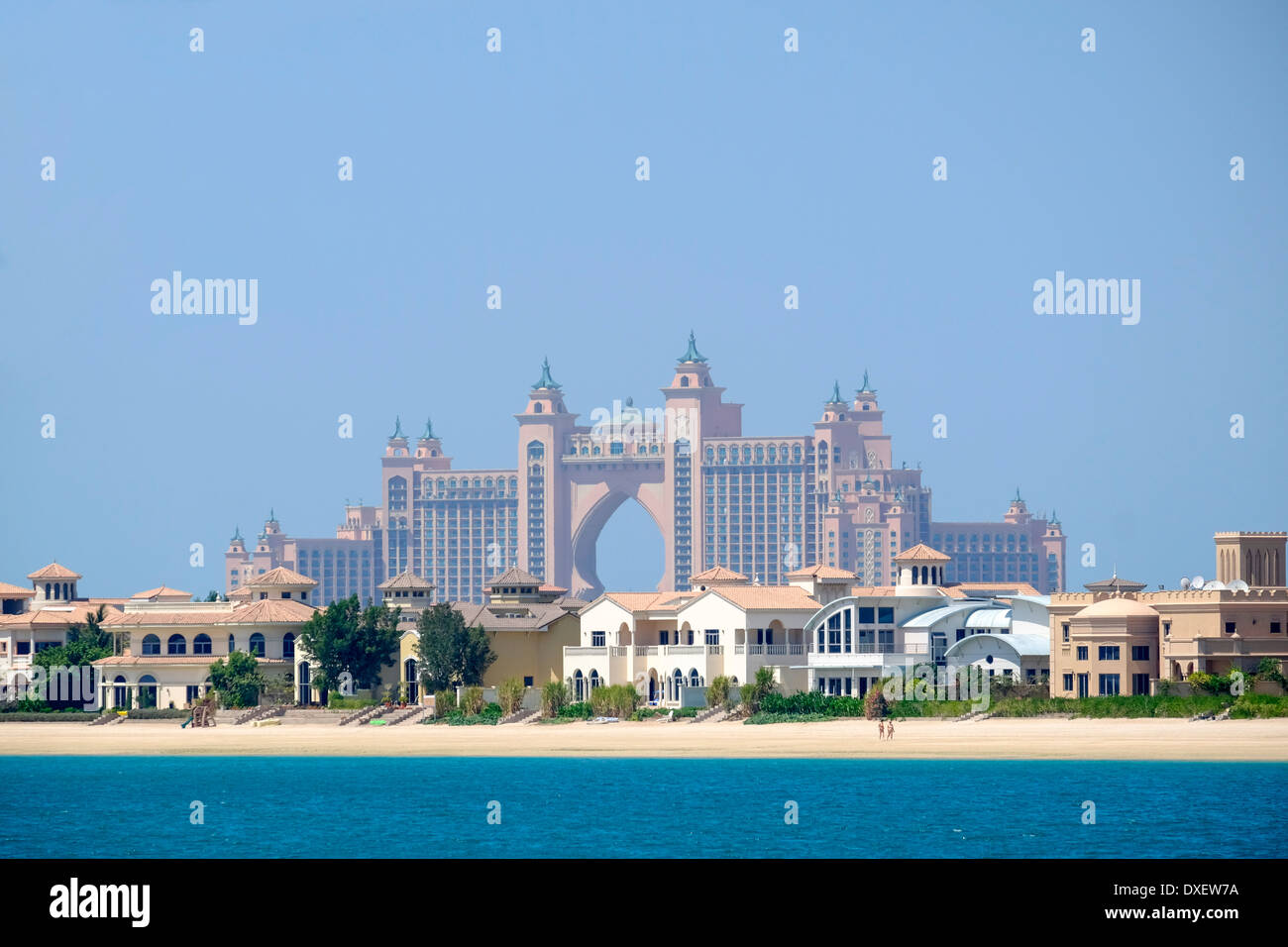 Luxury villas on frond of Palm Island man-made island with Atlantis the Palm hotel to rear in Dubai United Arab Emirates Stock Photo