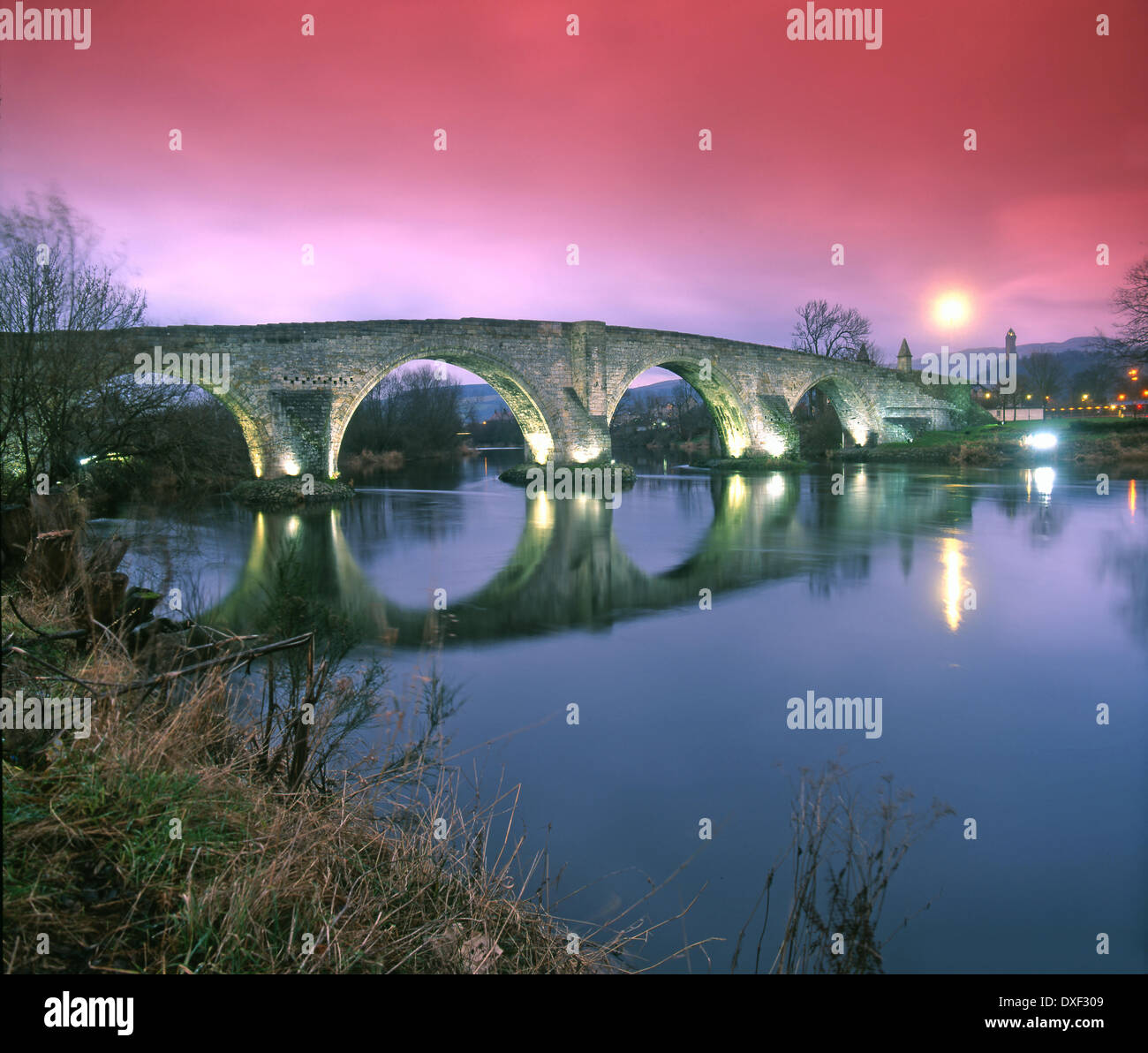 Dramatic light over old Stirling Bridge with a disitant Wallace monument in view. Central Scotland. Stock Photo