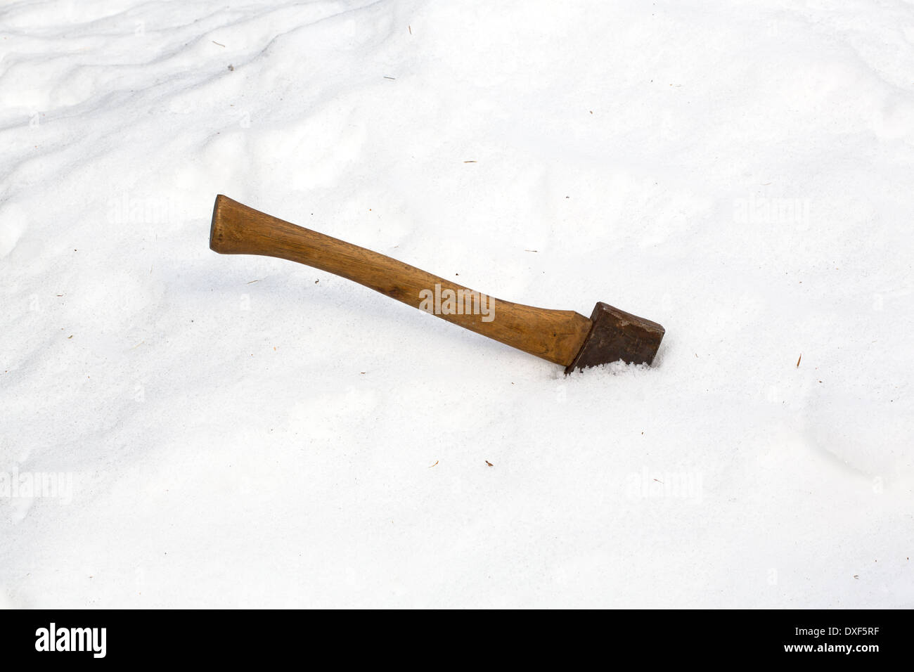 An old ax with the blade buried in a snowbank. Stock Photo