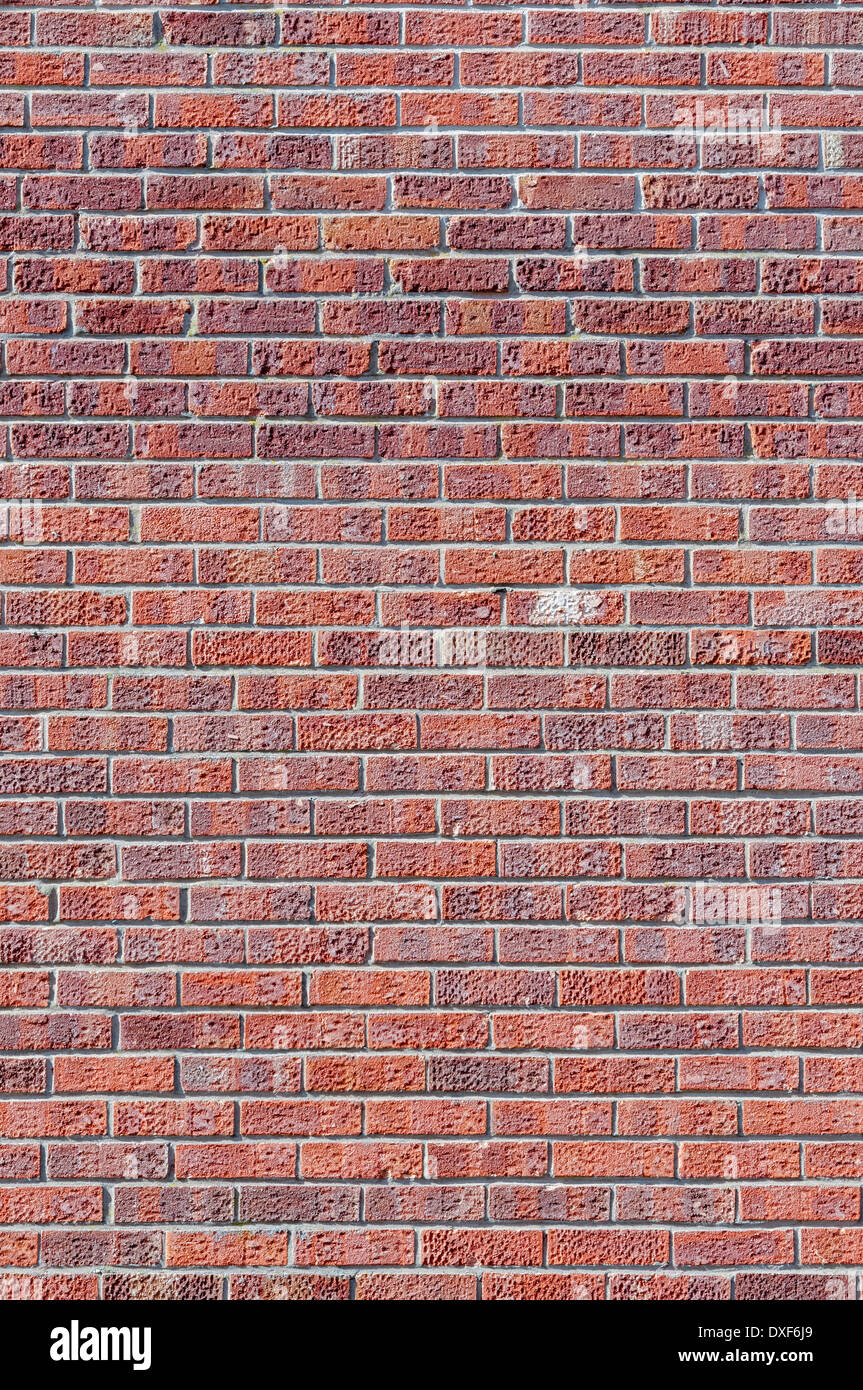 Pocked and stained red brick wall; portrait orientation. Stock Photo