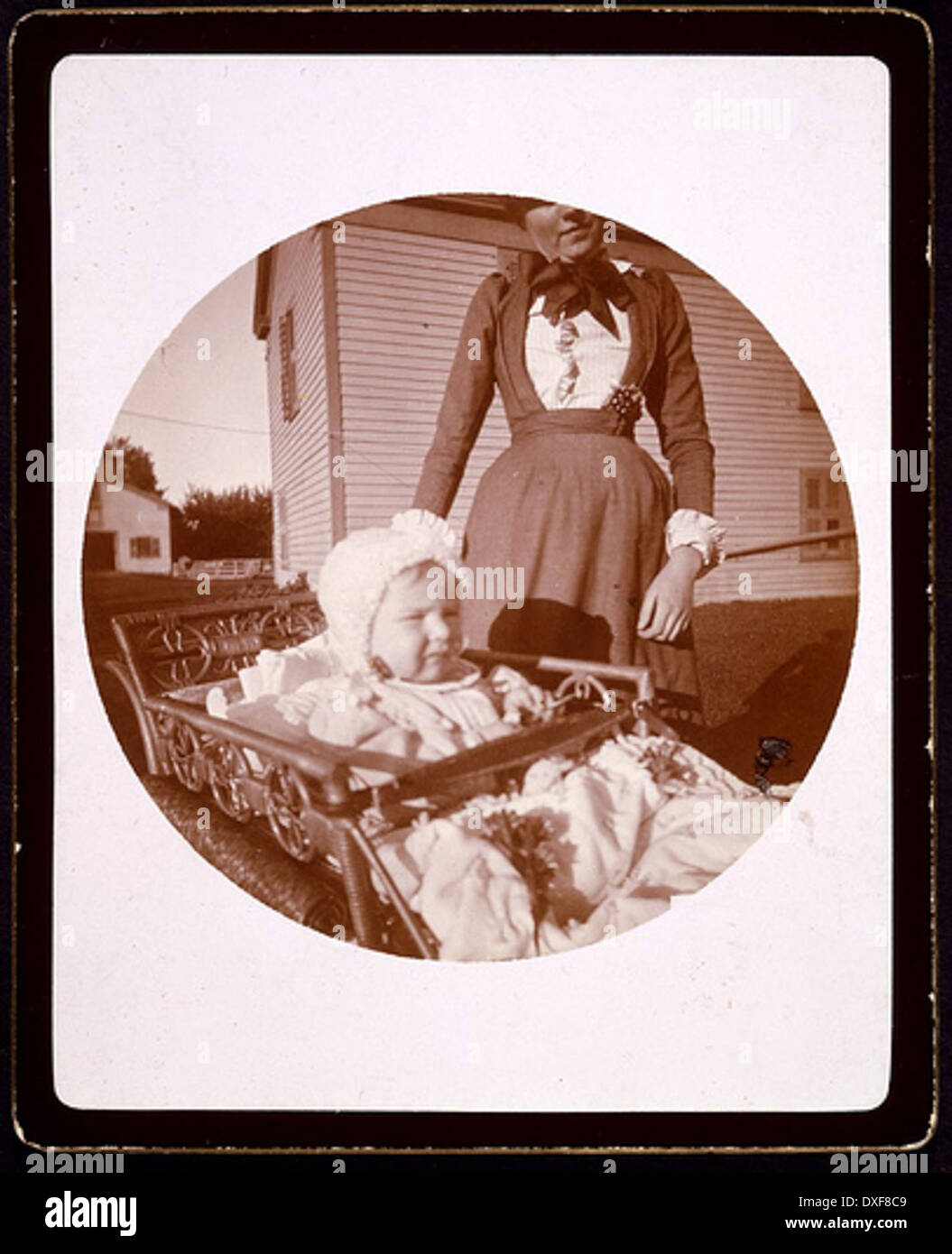 Baby in carriage, woman standing behind Stock Photo