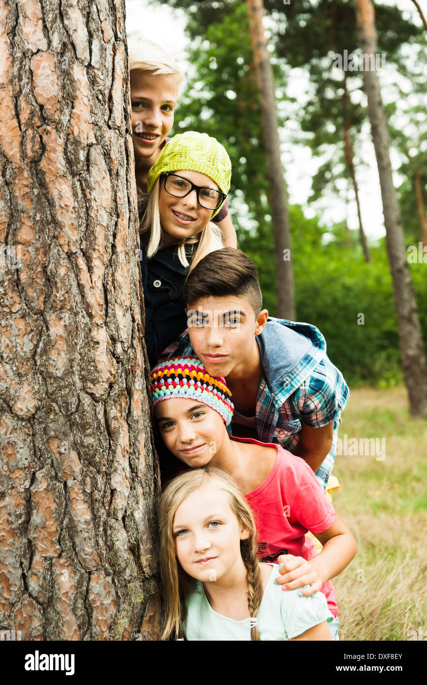 Portrait of group of children posing next to tree in park, Germany Stock Photo