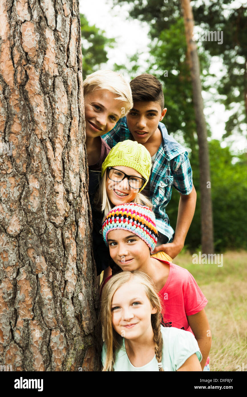 Portrait of group of children posing next to tree in park, Germany Stock Photo