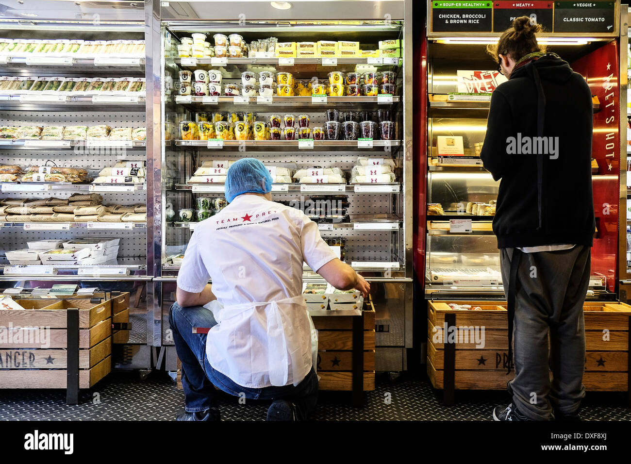 A member of the Pret a Manger staff stocking shelves. Stock Photo