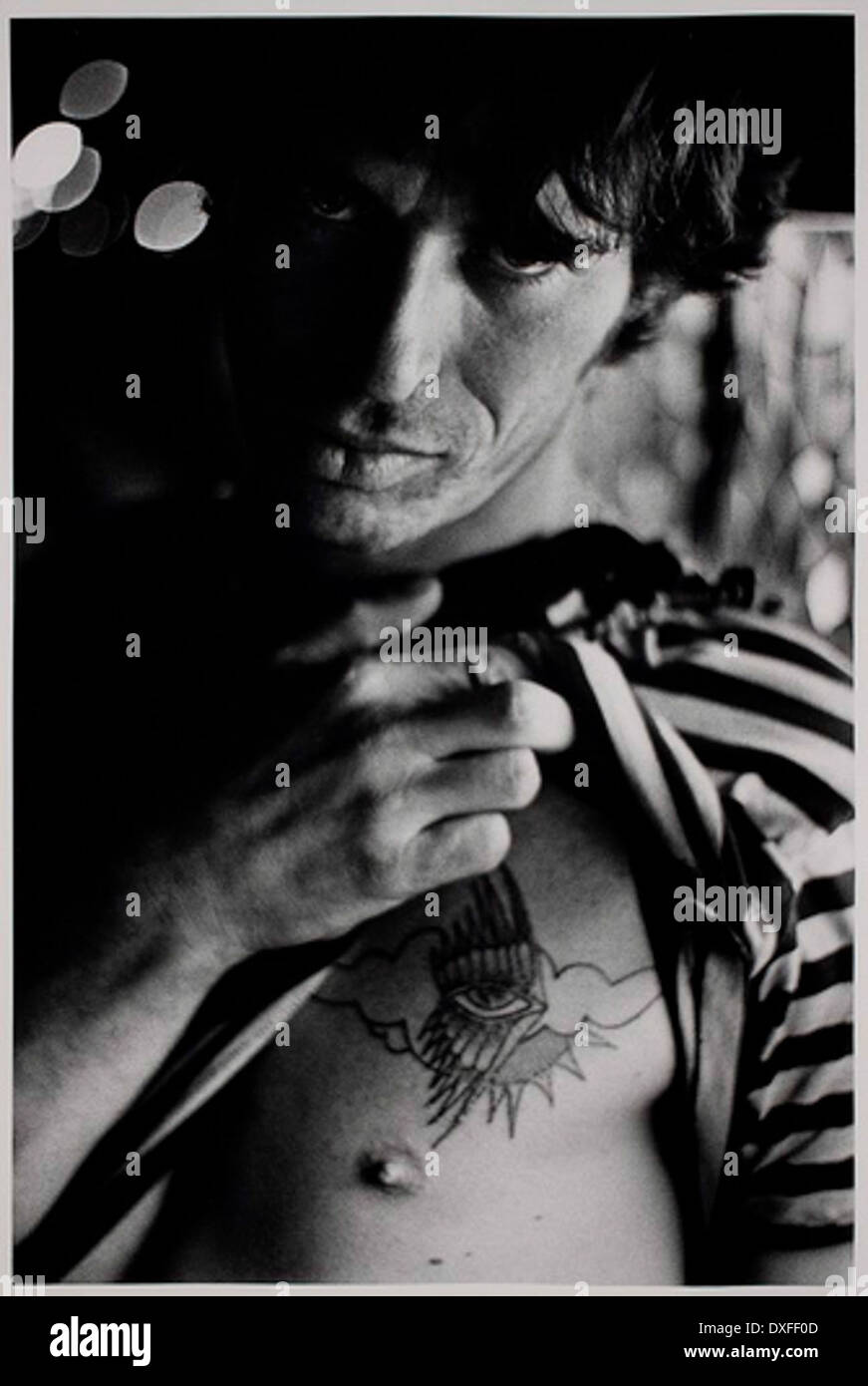 [MAN IN STRIPED SHIRT SHOWING TATTOO] Stock Photo