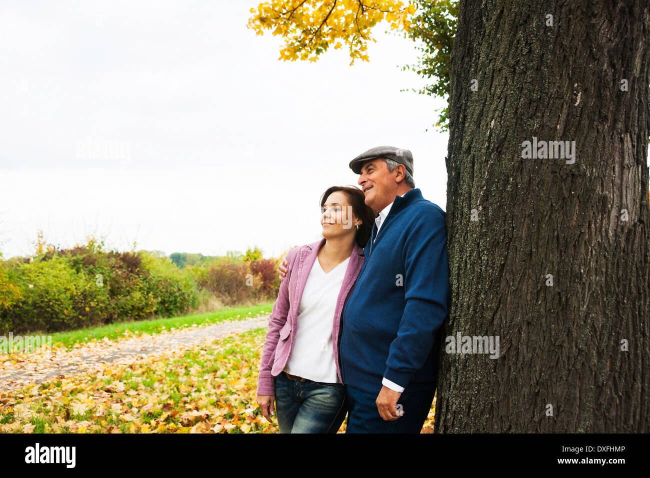 Couple leaning against Tree Trunk, Mannheim, Baden-Wurttmeberg, Germany Stock Photo