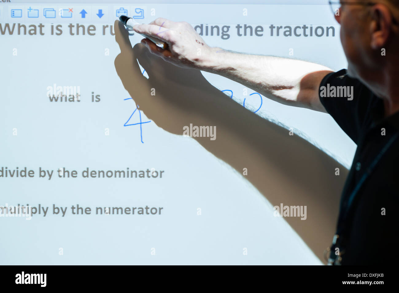 A teacher using an interactive touch sensitive digital white board in a classroom Wales UK Stock Photo