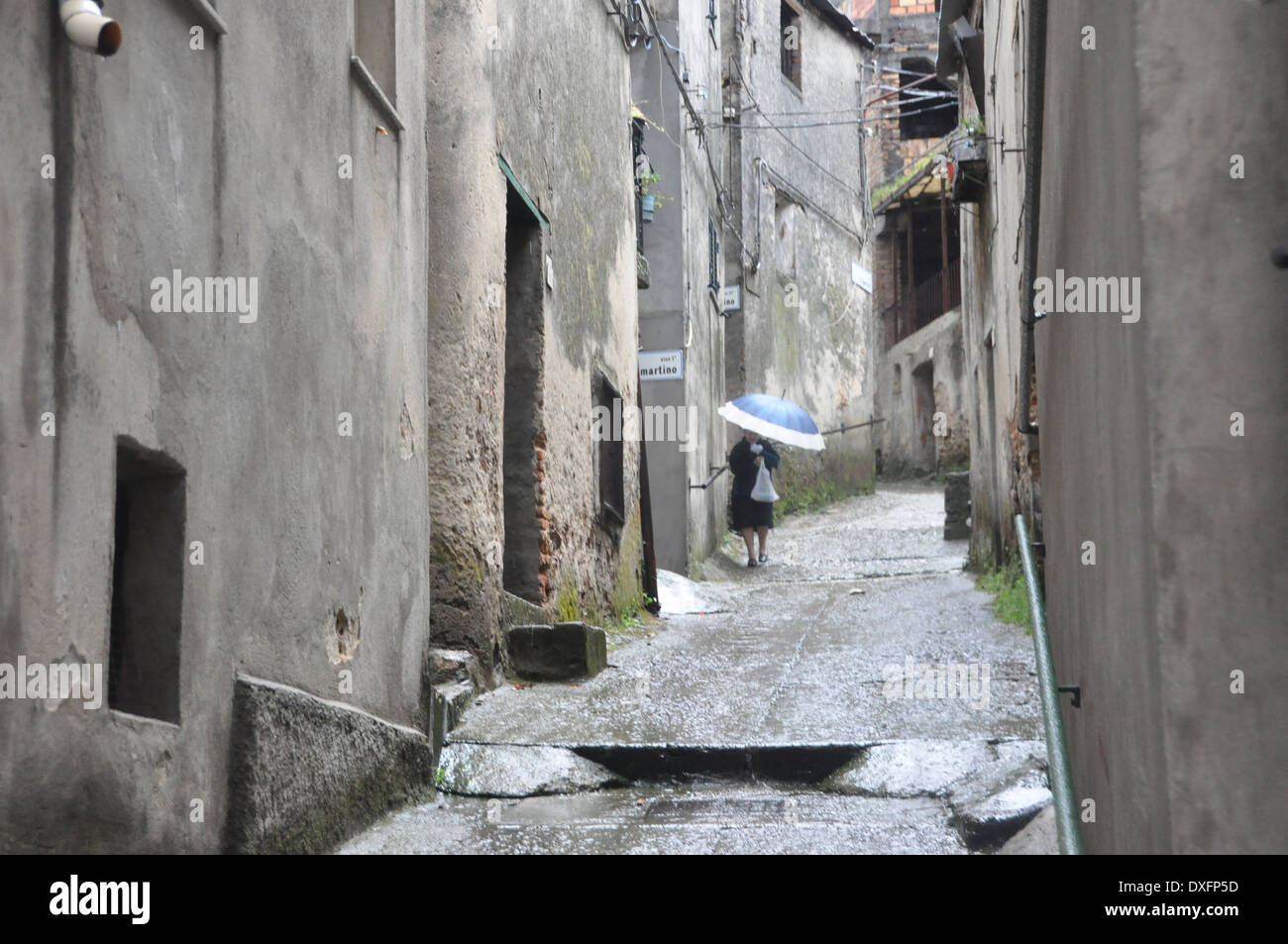Old Italian lady walking in a narrow street in the Southern Italian village of Delianuova Calabria Stock Photo