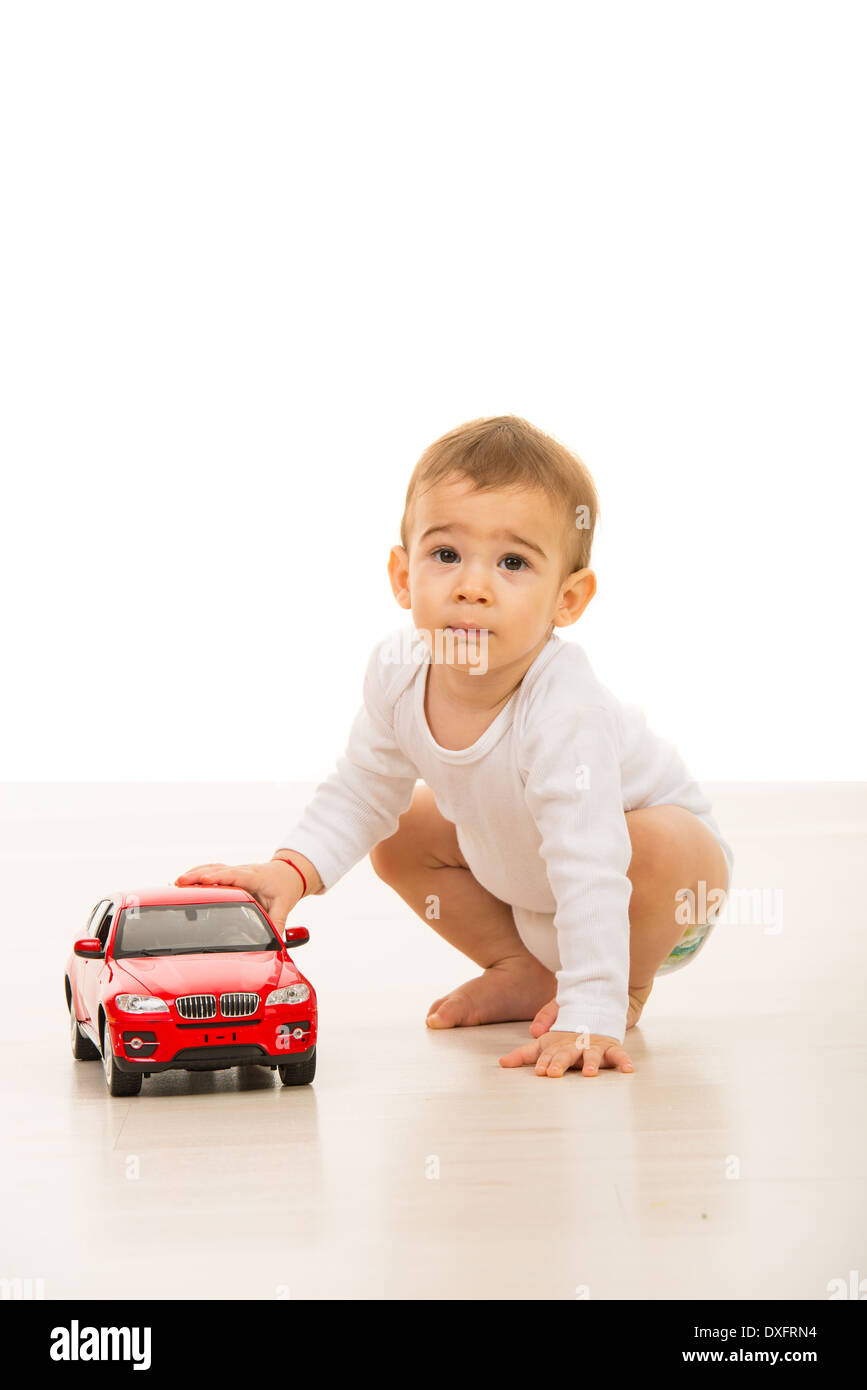 Lovely baby boy playing with a big car toy on floor Stock Photo - Alamy