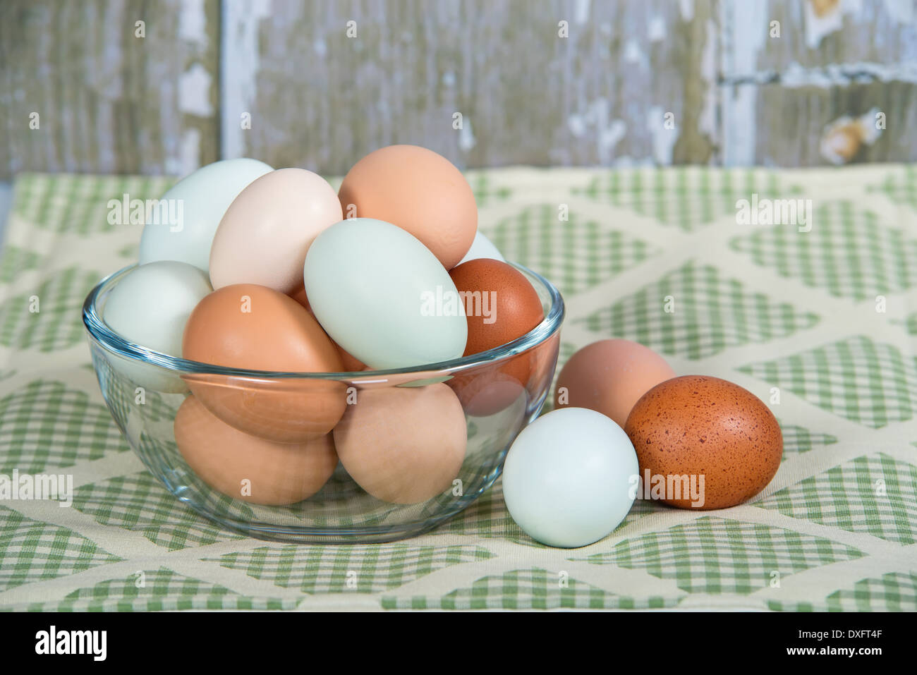Assortment of different color, fresh, chicken eggs in a glass bowl. Background country kitchen style. Stock Photo